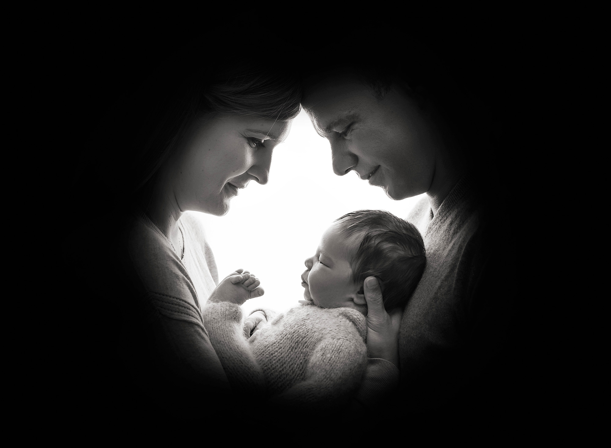 | Nature Lover Newborn Photos silhouette shadow of parents face's while cradling their newborn baby boy