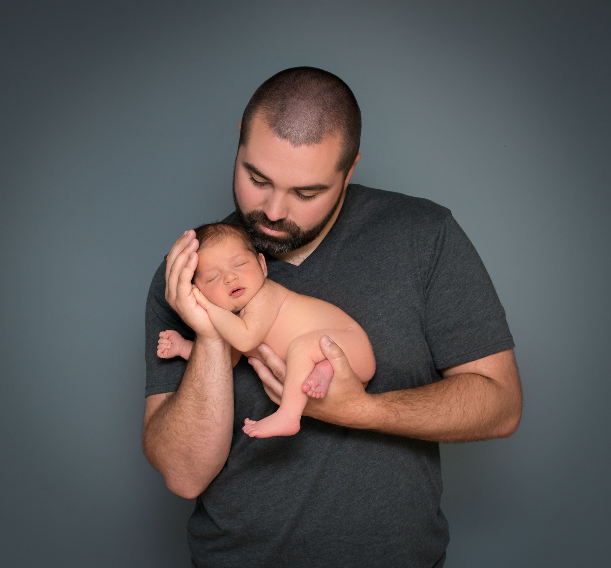 Dad holding newborn son in his hands