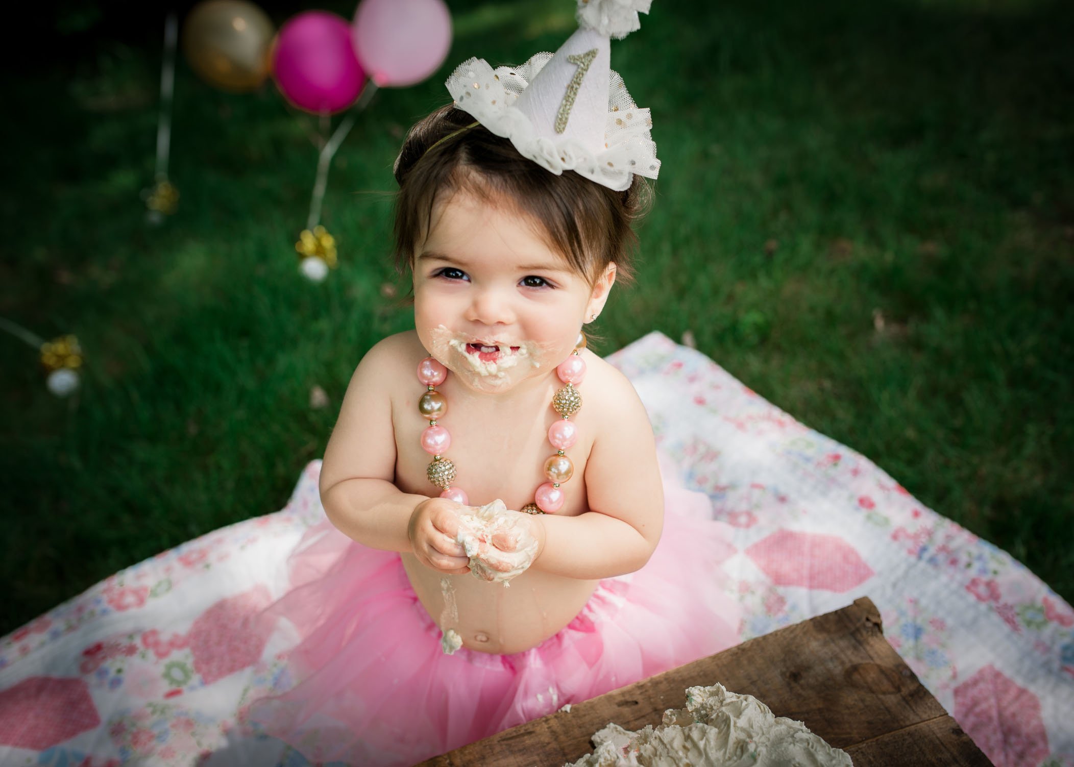 little girl in tutu covered in cake and icing