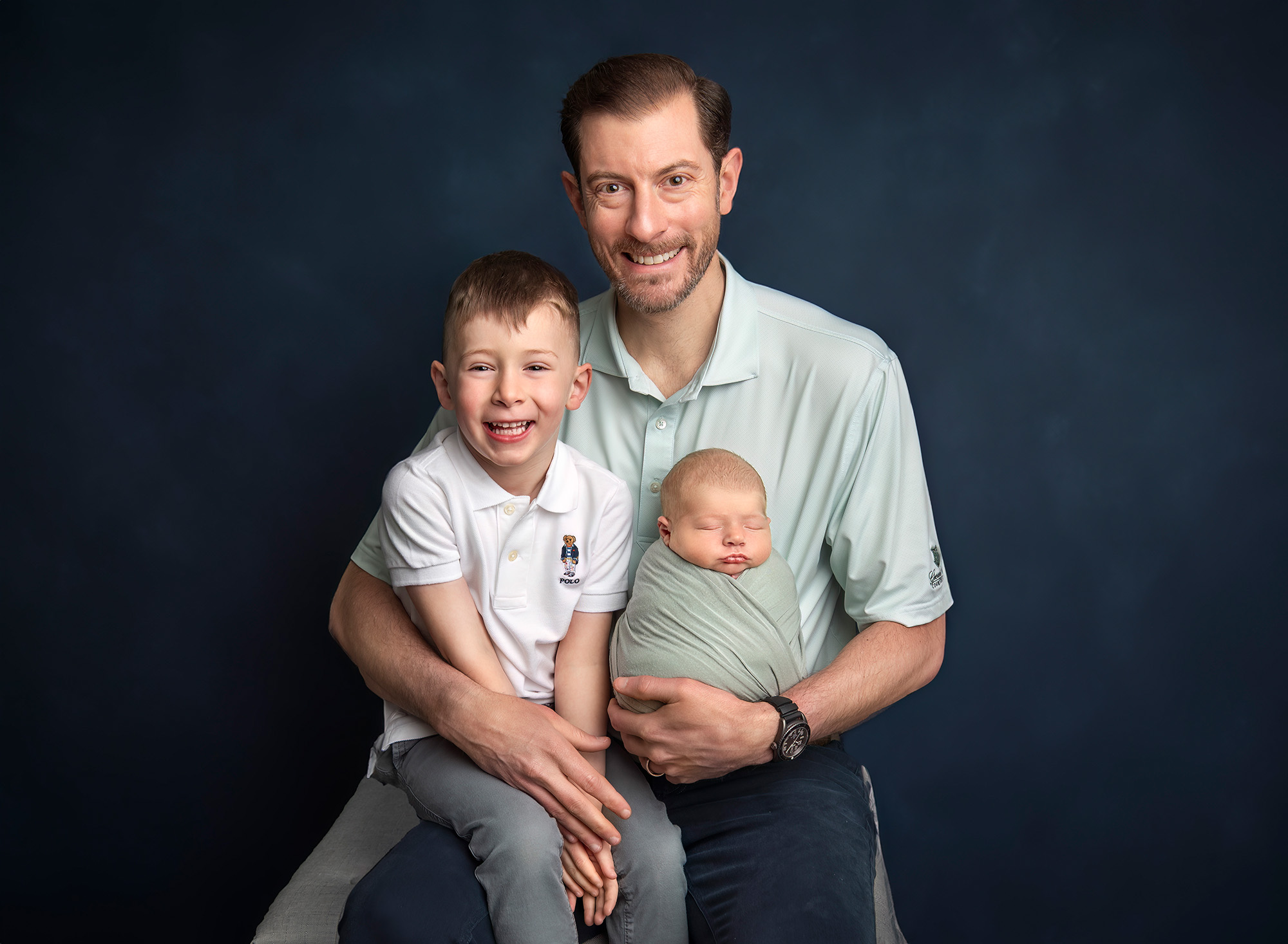 Dad smiling with both children seated in his lap