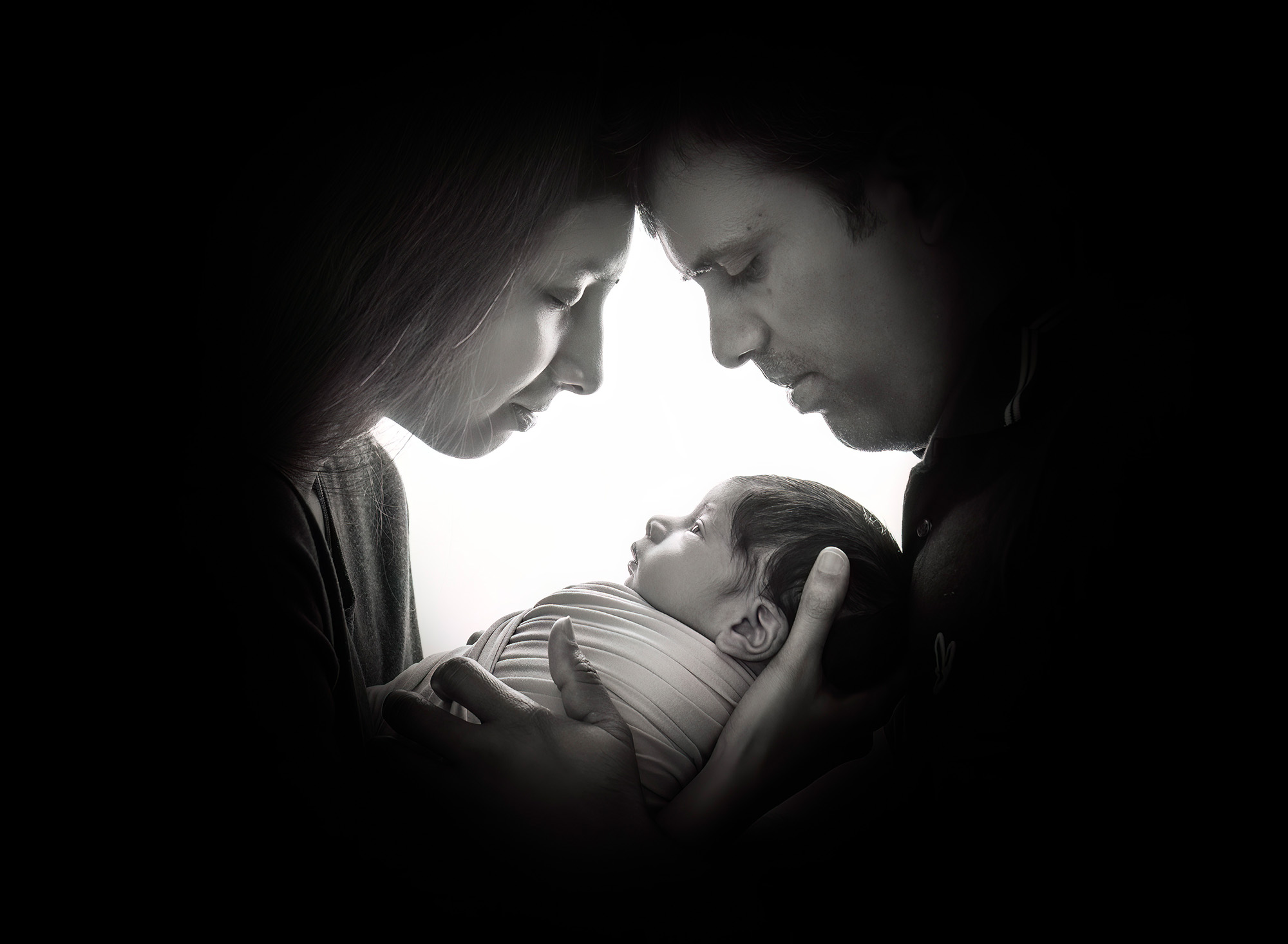 parents cradling baby in a black and white keyhole image Fine Art Newborn Photography