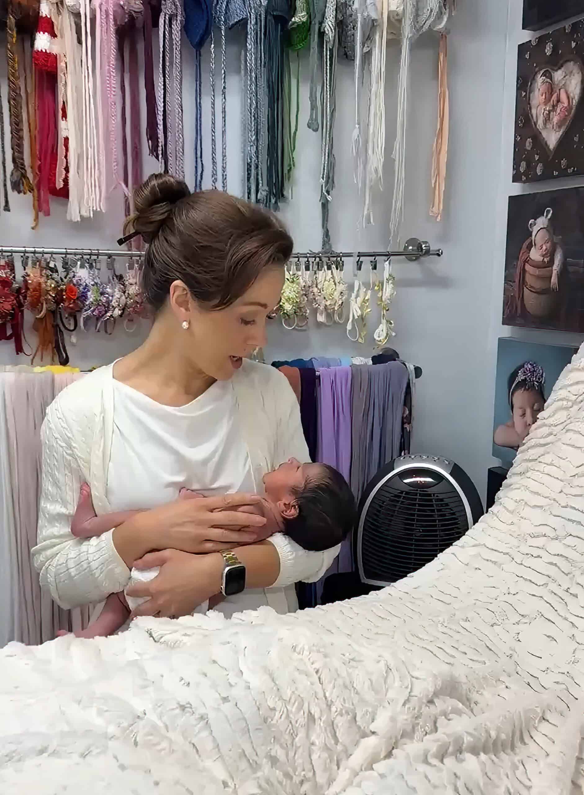 best newborn photographer newborn photographer safely holding baby during photo session