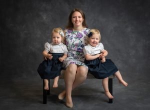 identical twin girls posing with their mother