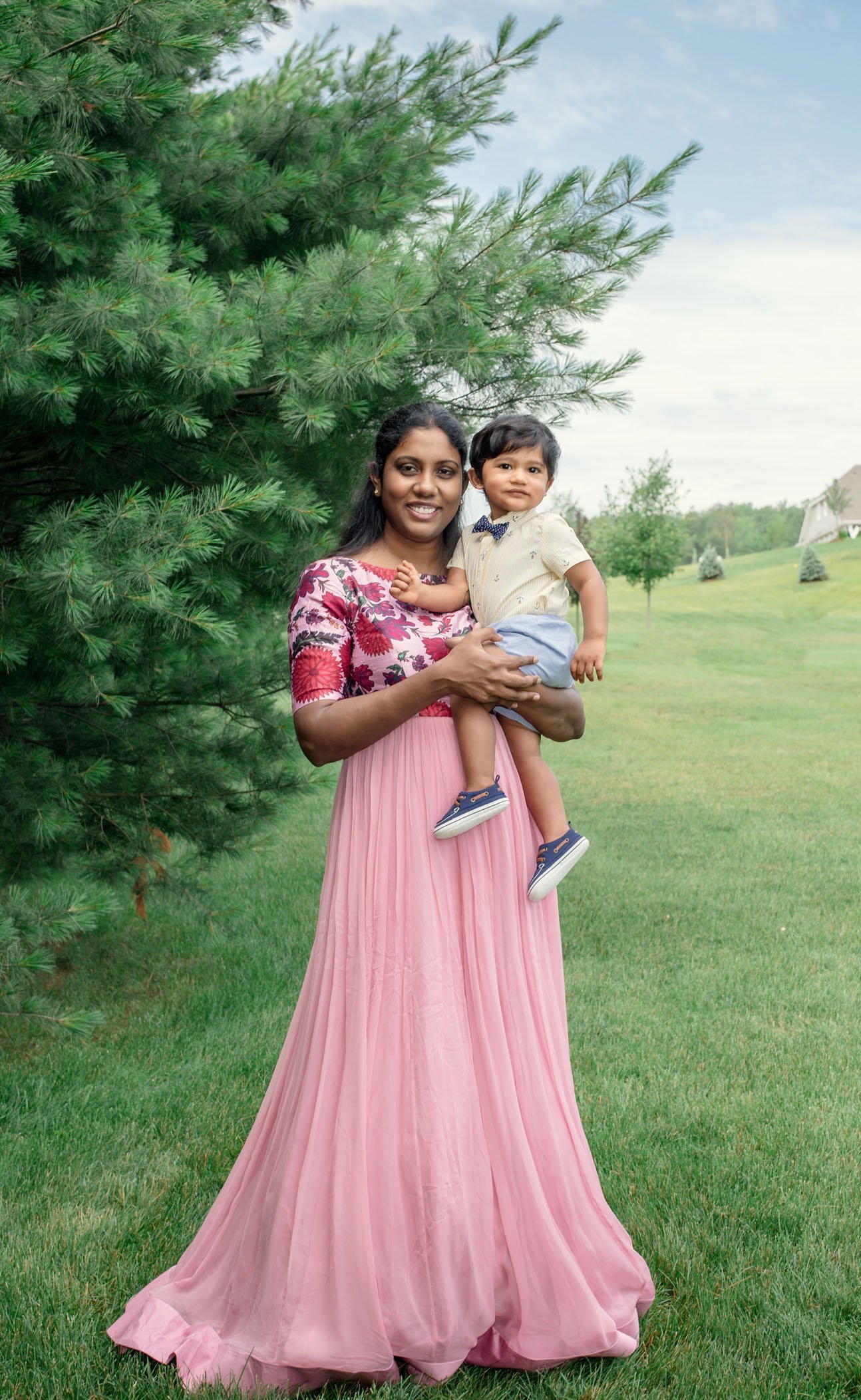 Mom holding her 8 mo old boy on her hip in long pink dress