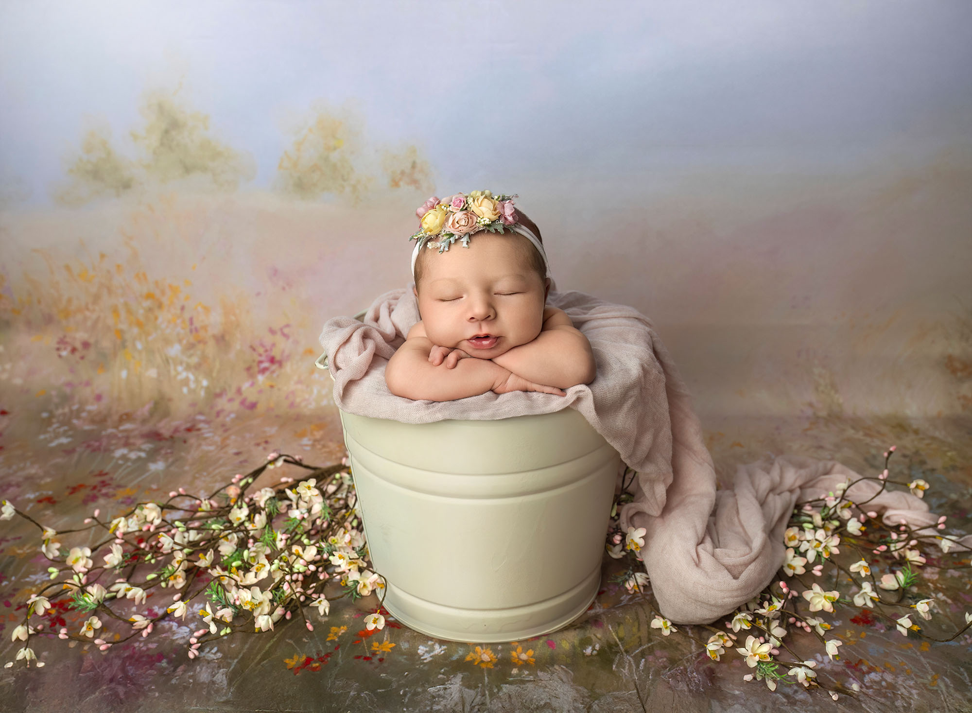 Newborn in bucket pose with floral crown—safe setup after preparing siblings for newborn photos