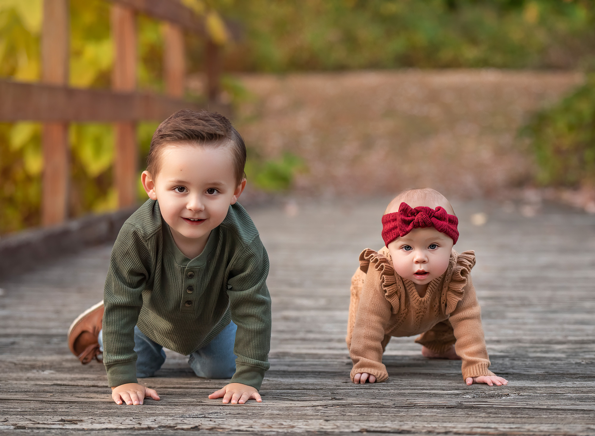 Lincoln and Kennedy crawling on a wood bridge in fall. 