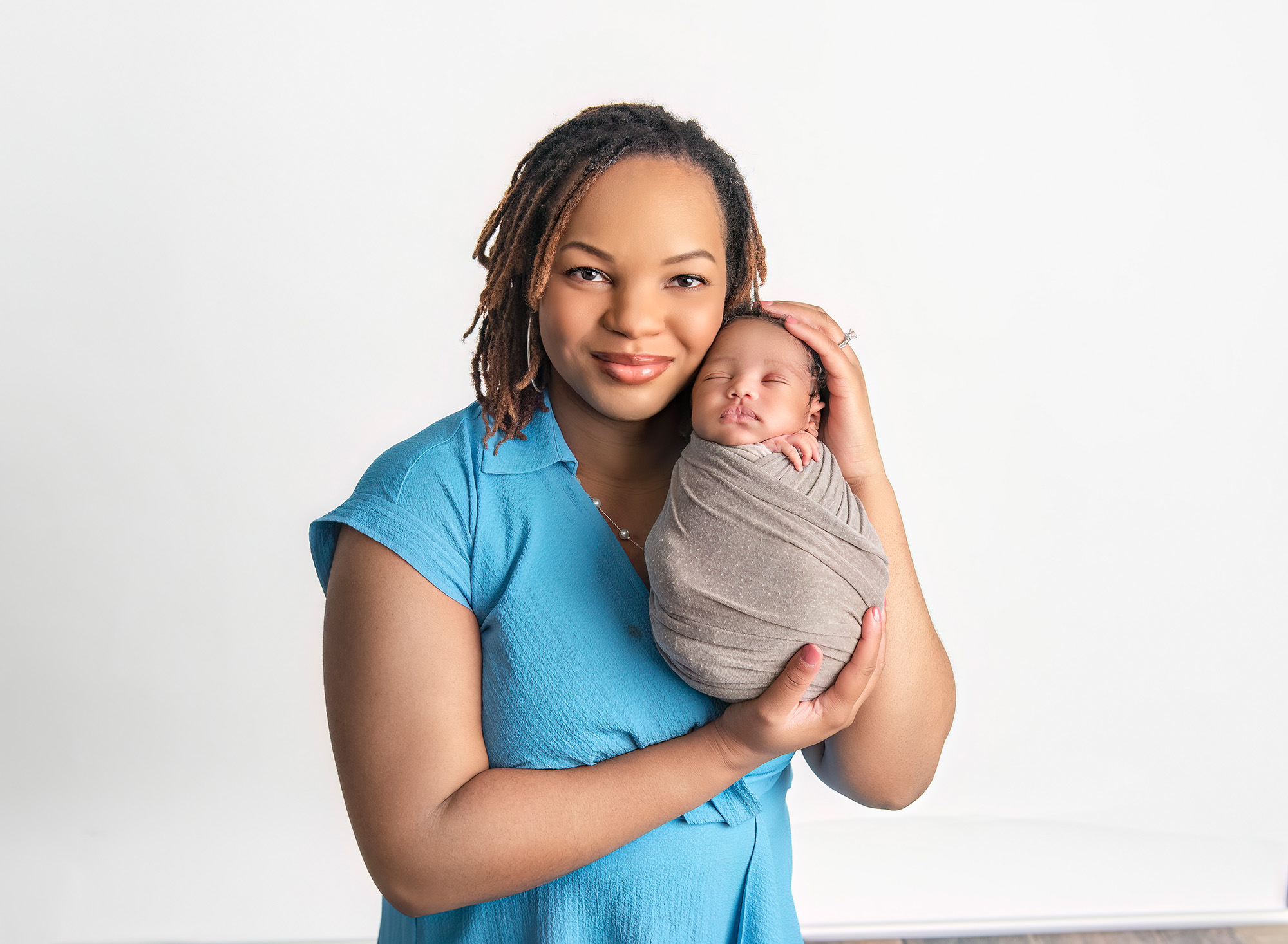 Mom cradling newborn son against her cheek