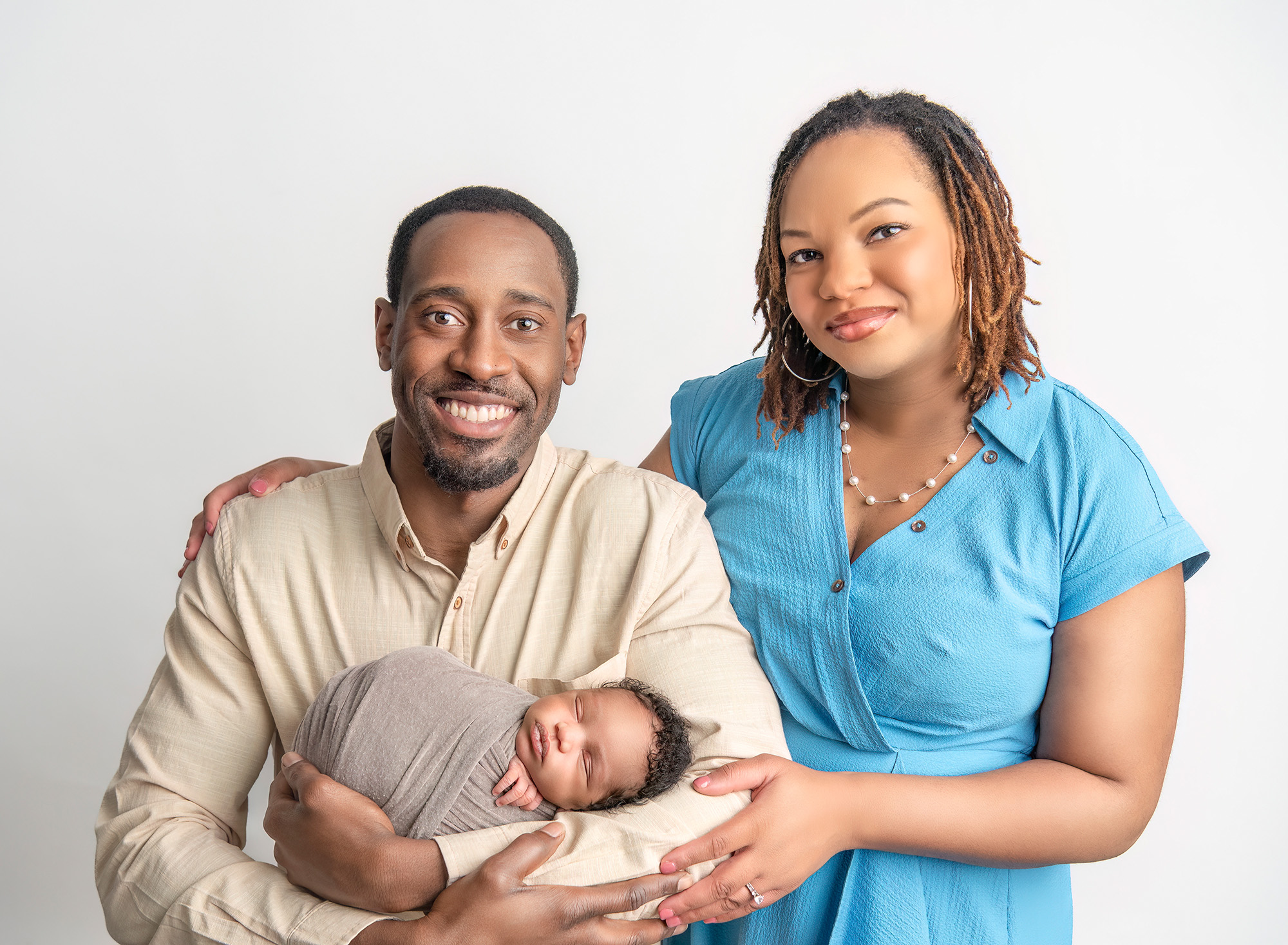 Dad cradling newborn son in family portrait