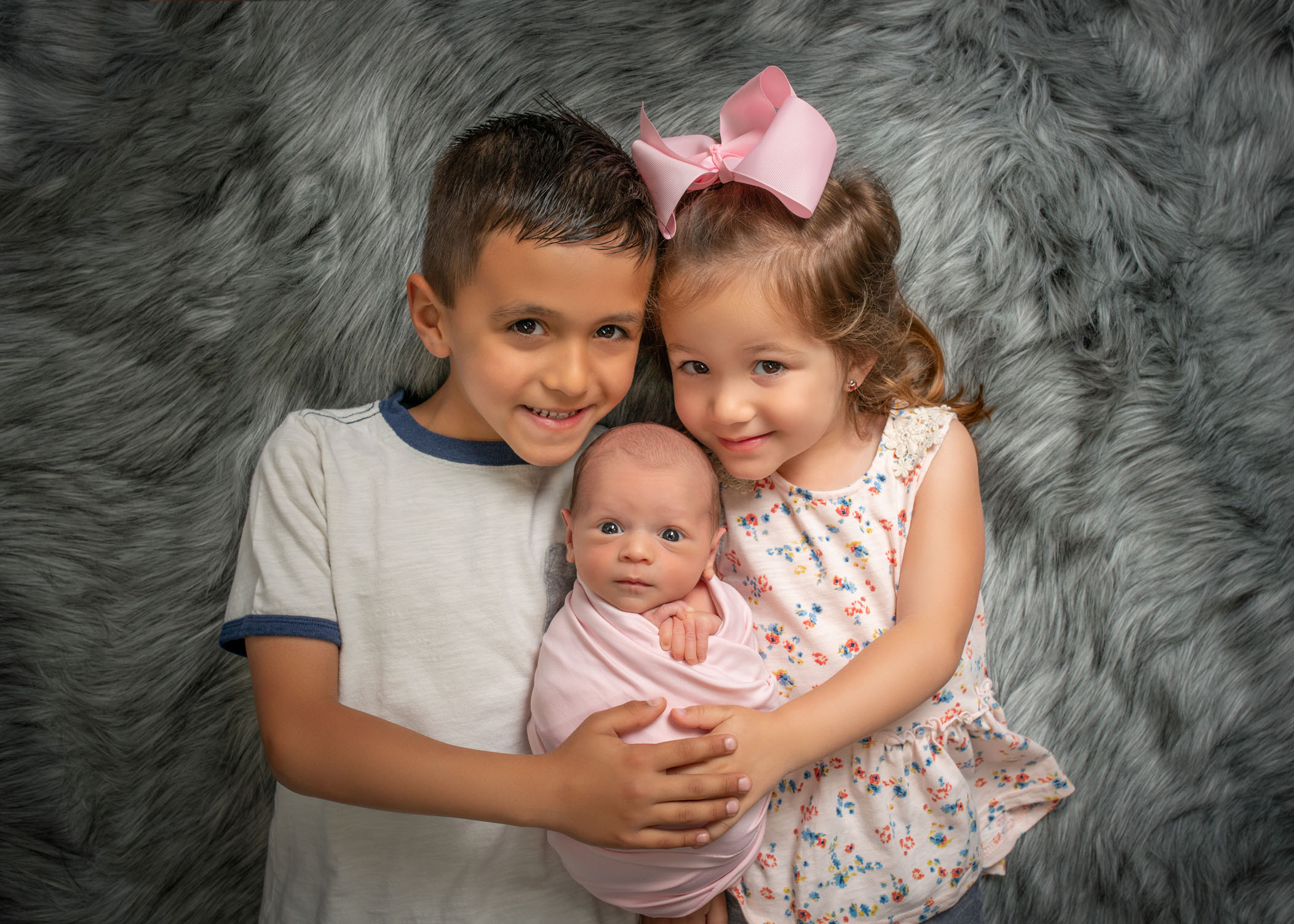 boy and girl cousins hold their newborn baby girl cousin