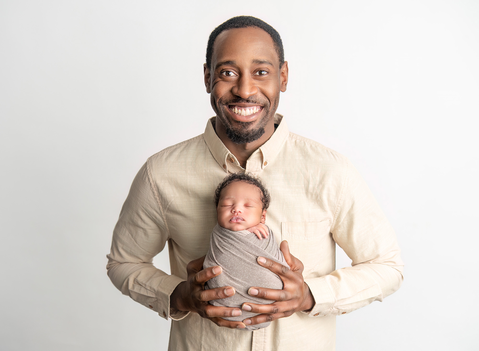 dad holding newborn son against his chest