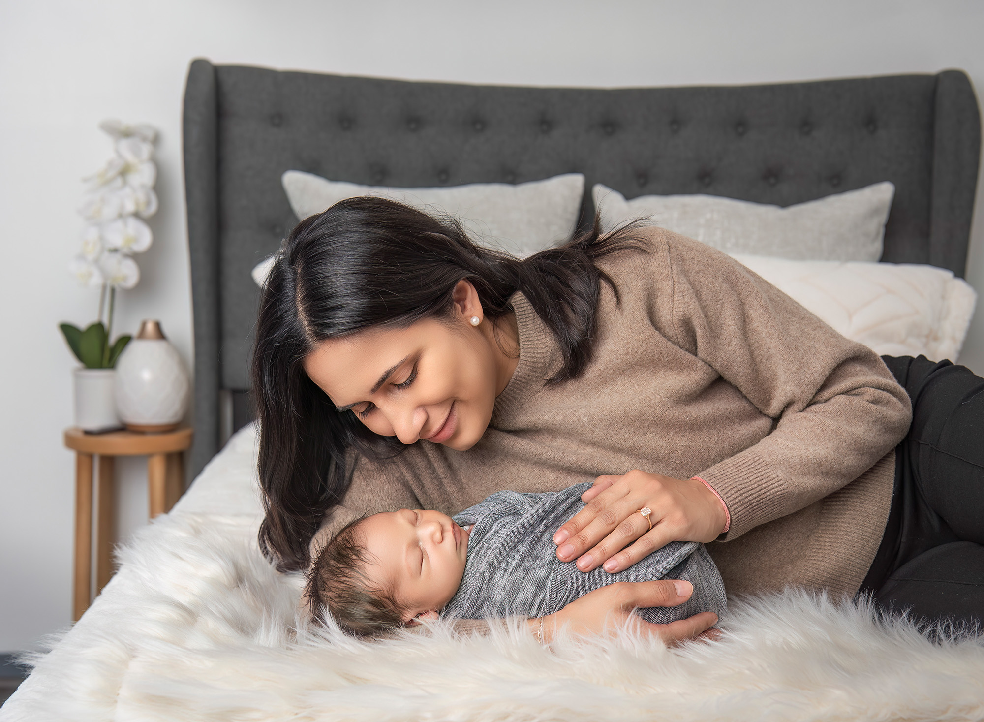 Mom cradling newborn son while looking down at him