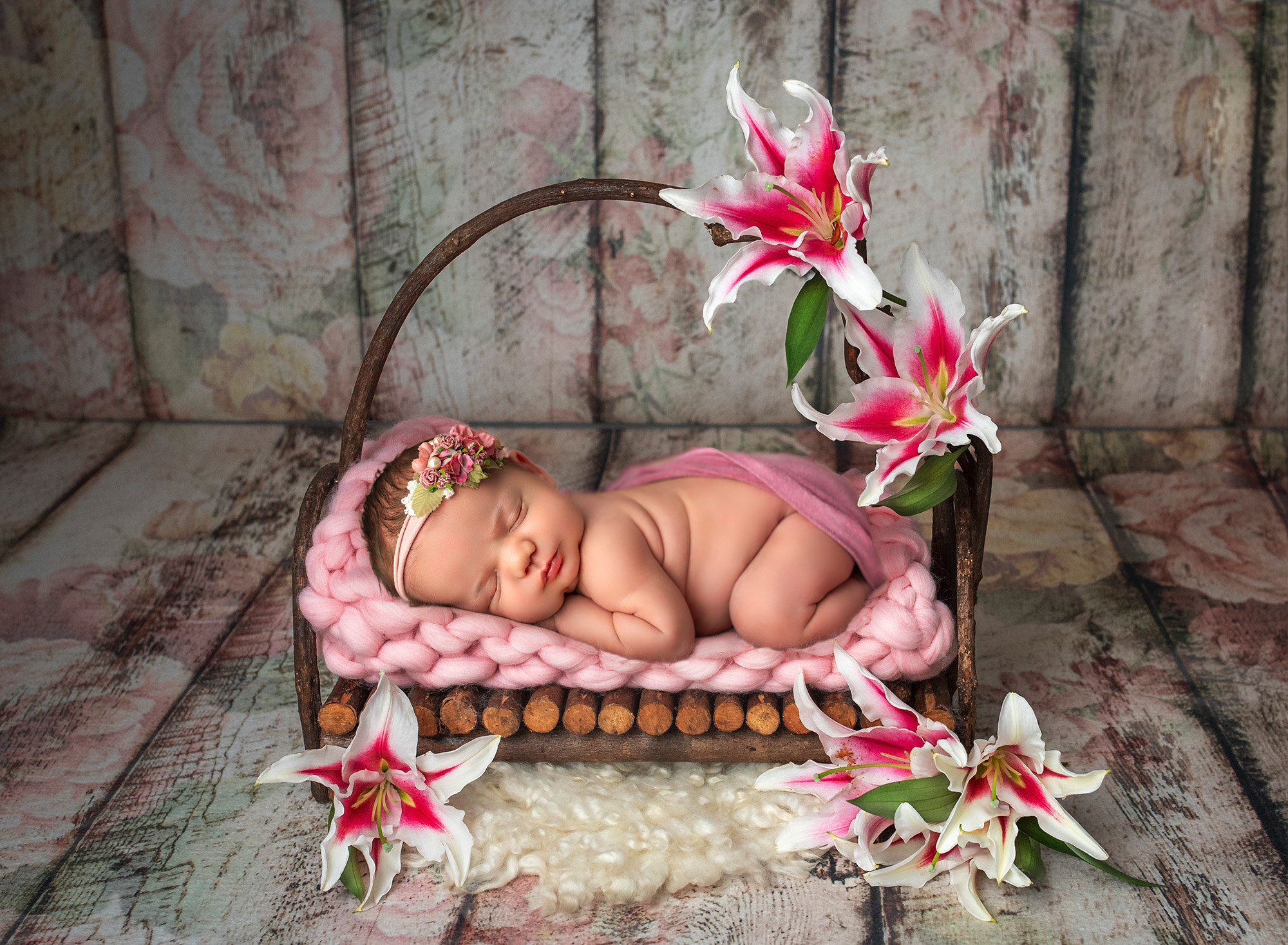 Newborn girl sleeping on a rustic bed, surrounded by vibrant Tiger Lilies and Peonies