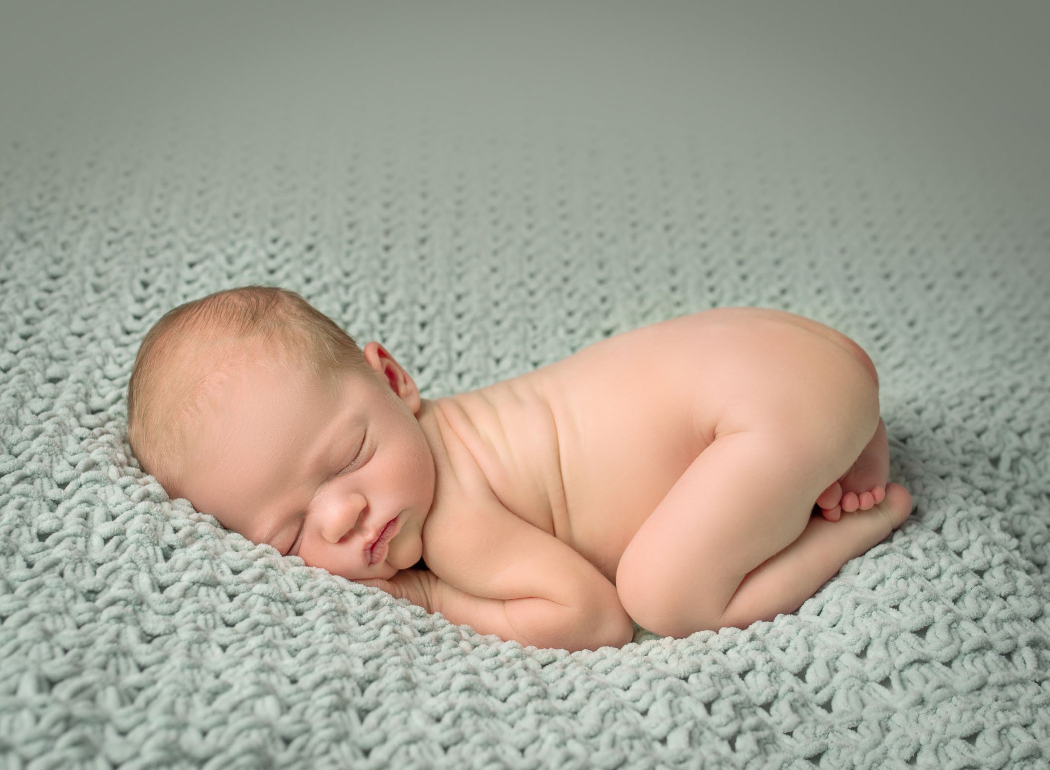 Newborn baby photo sleeping on mint green blanket in bum up pose