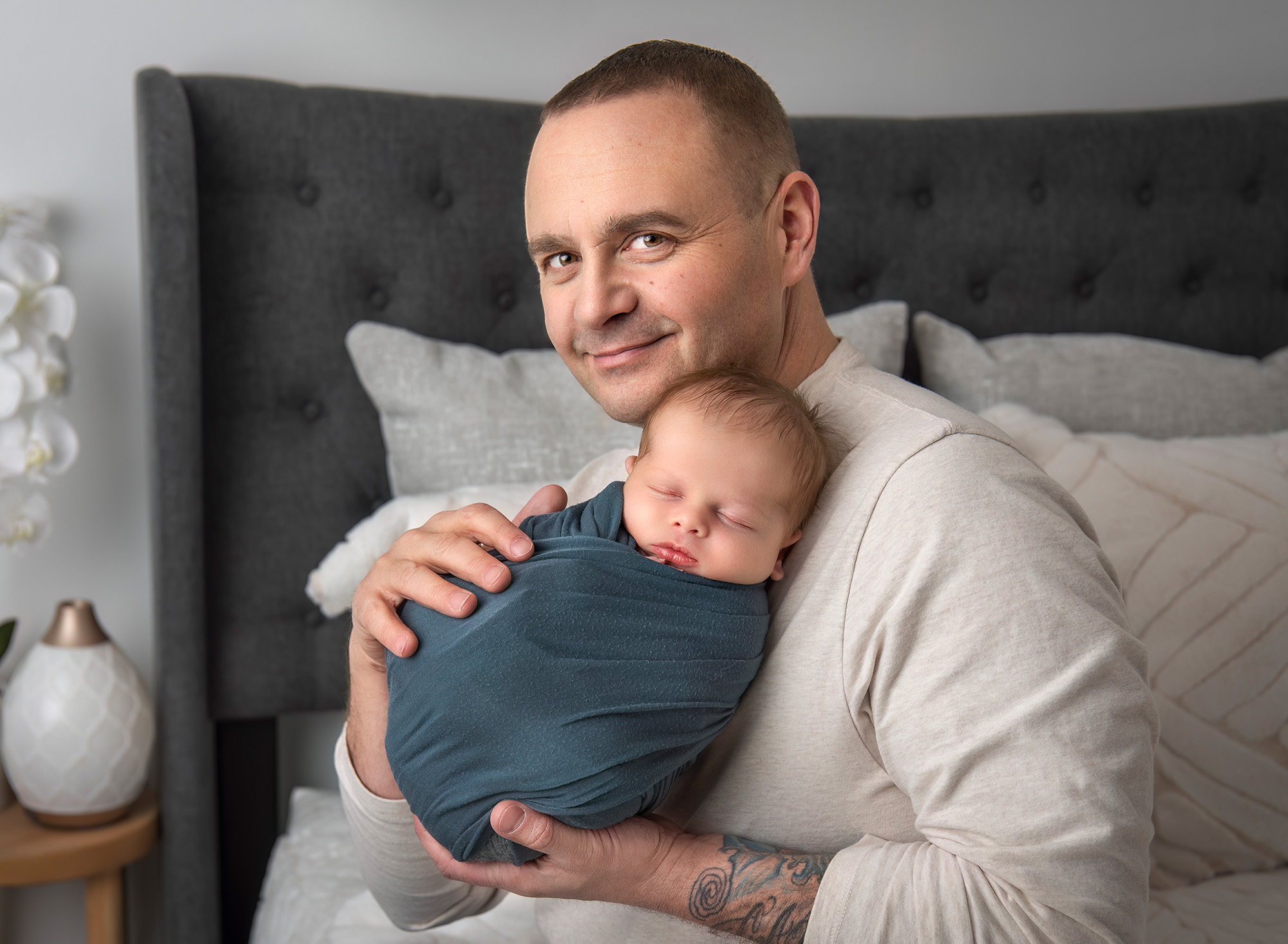 A sleeping newborn cradled against dad’s chest