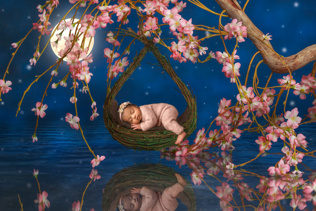 best time to do a newborn photoshoot sleeping girl on basket with cherry tree blossoms