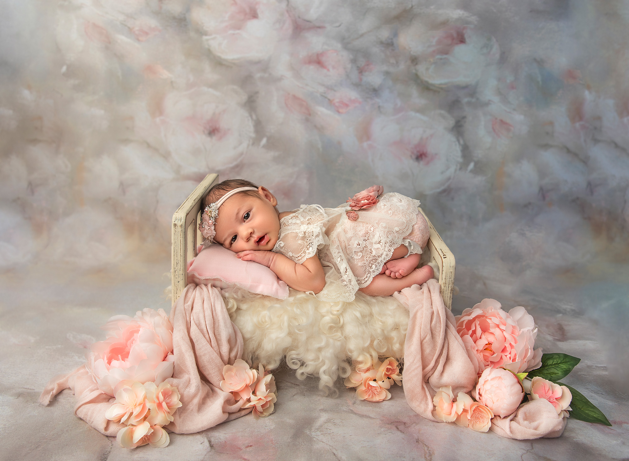 professional newborn photography baby girl laying on a painted bed surrounded by peonies on a peony background