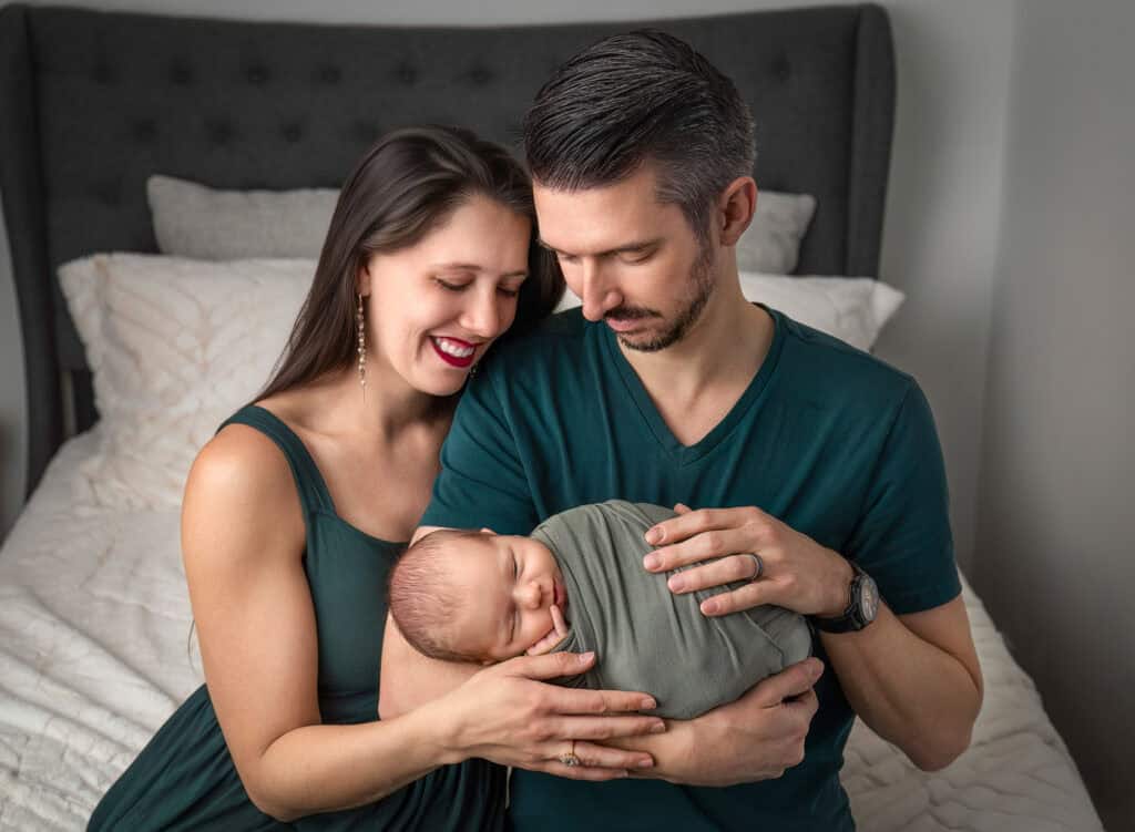 newborn photoshoot checklist parents admiring sleeping baby Leif in close embrace