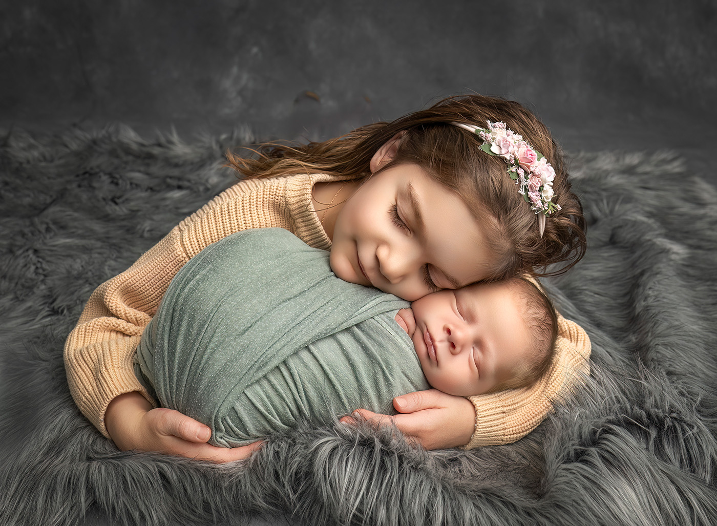 big sister and new baby brother snuggling 