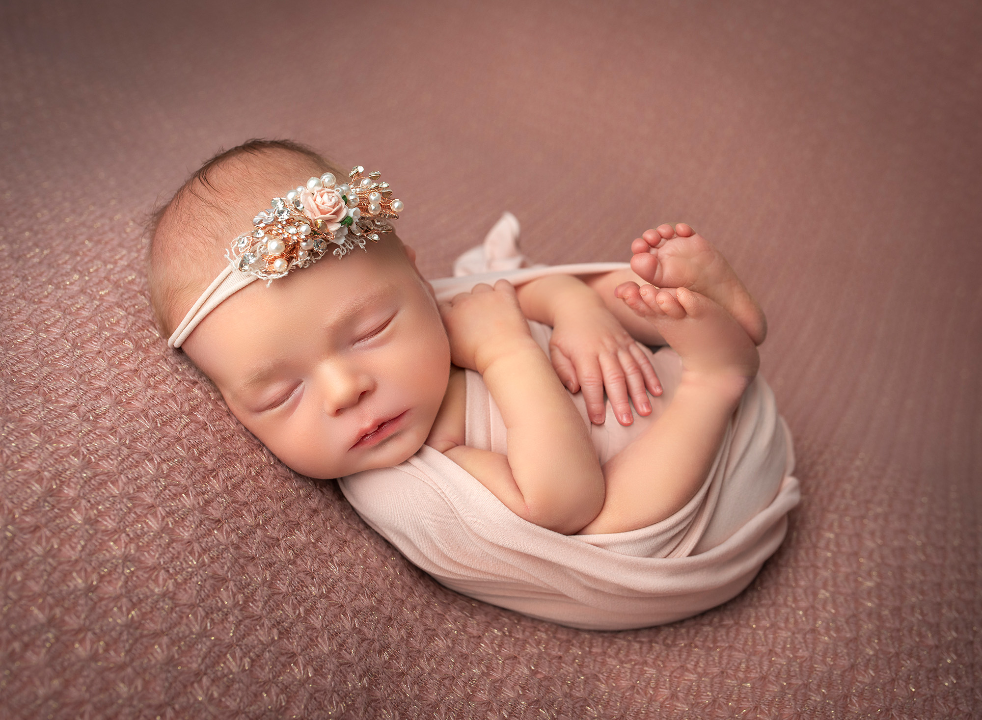 when should you take newborn photos baby girl sleeping wrapped up