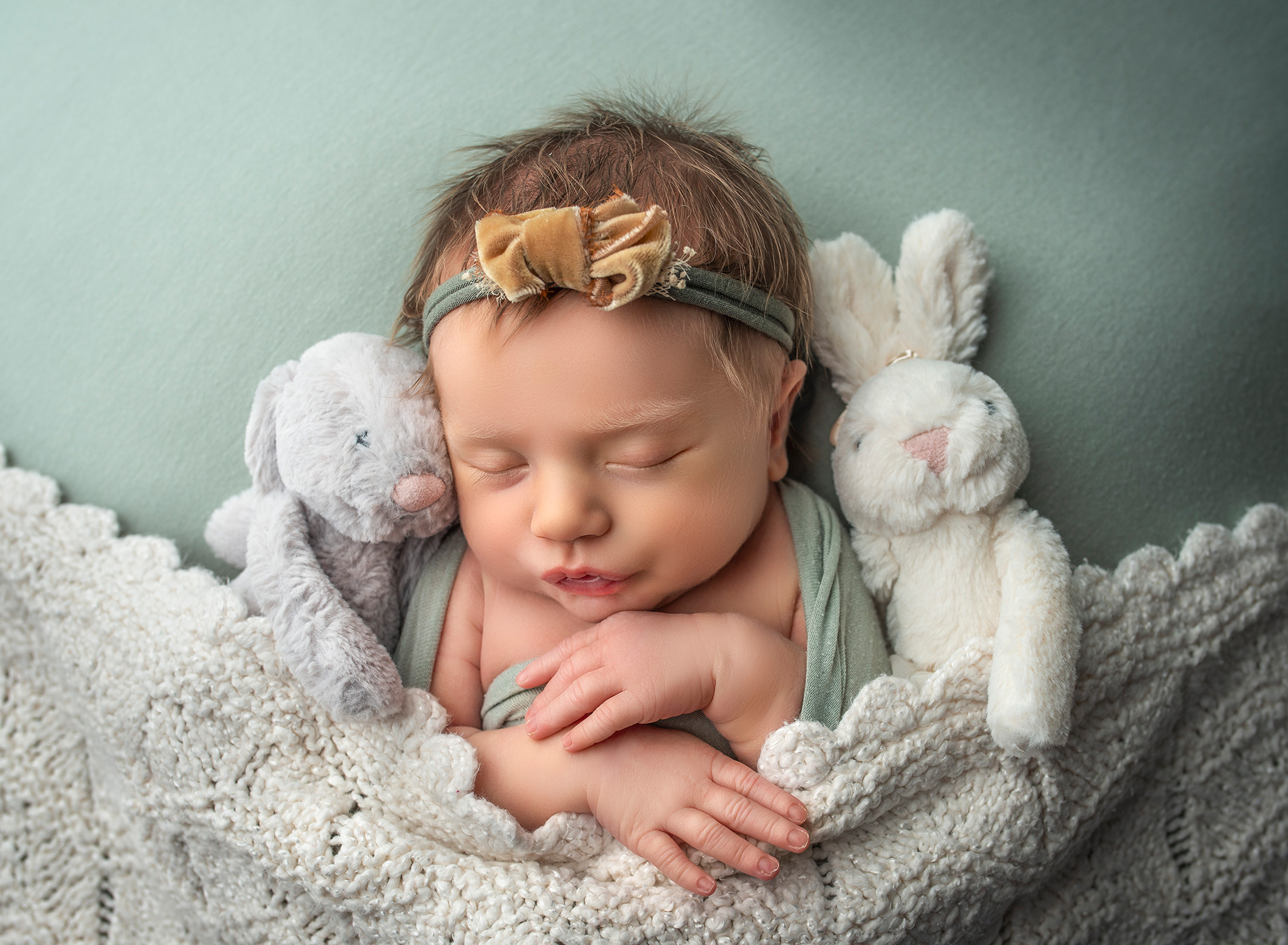 Best age for newborn photos little girl sleeping with her stuffed bunnies
