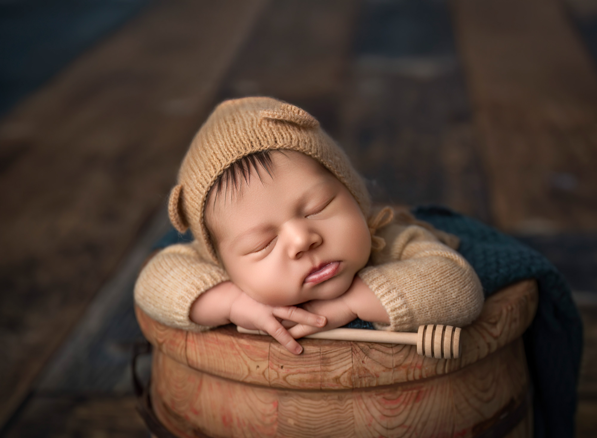 Honey-bear themed close-up with knit bonnet and wooden honey dipper.