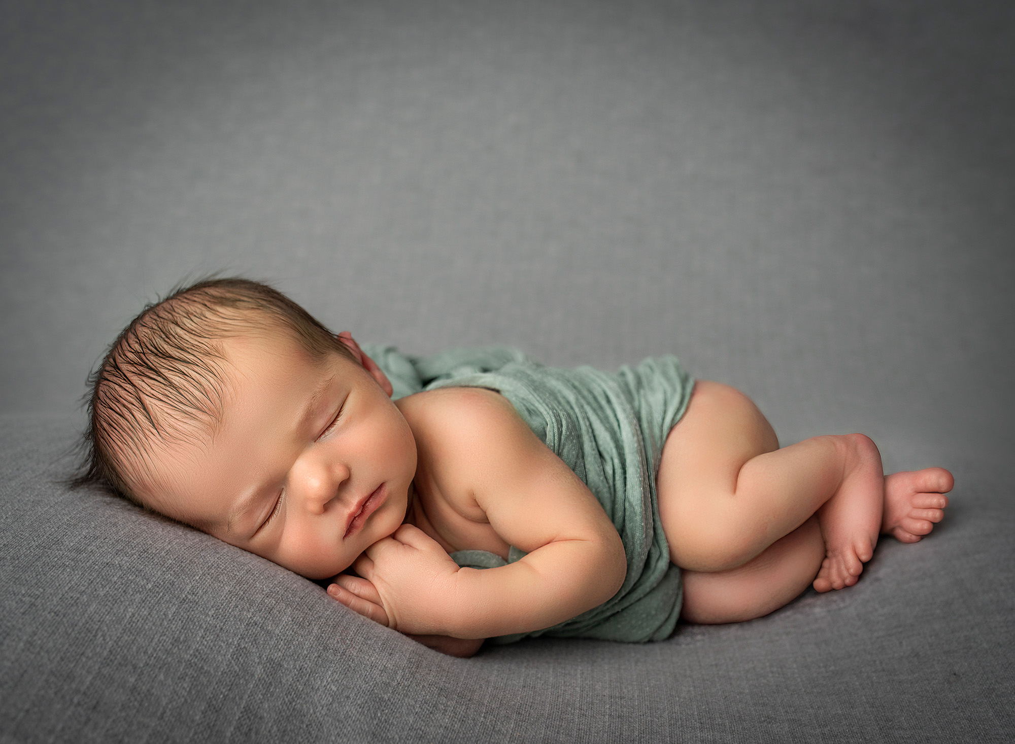 simple newborn boy photo lying on his side on grey background