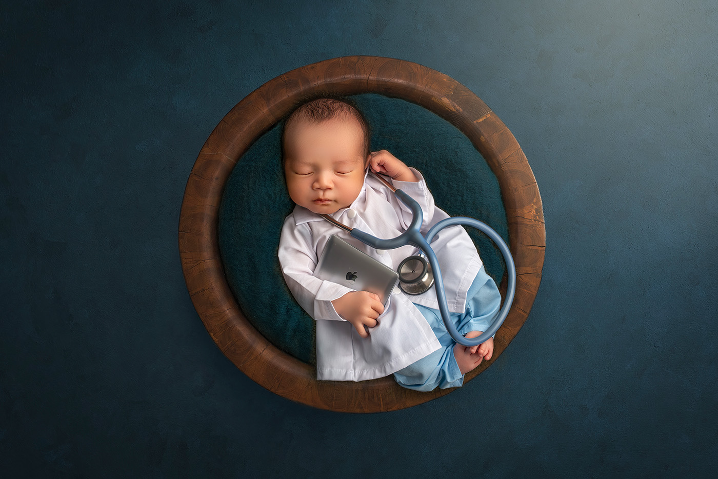 Vibrant Newborn Photos newborn baby dressed as a doctor in scrubs with a stethoscope and a laptop in a bowl