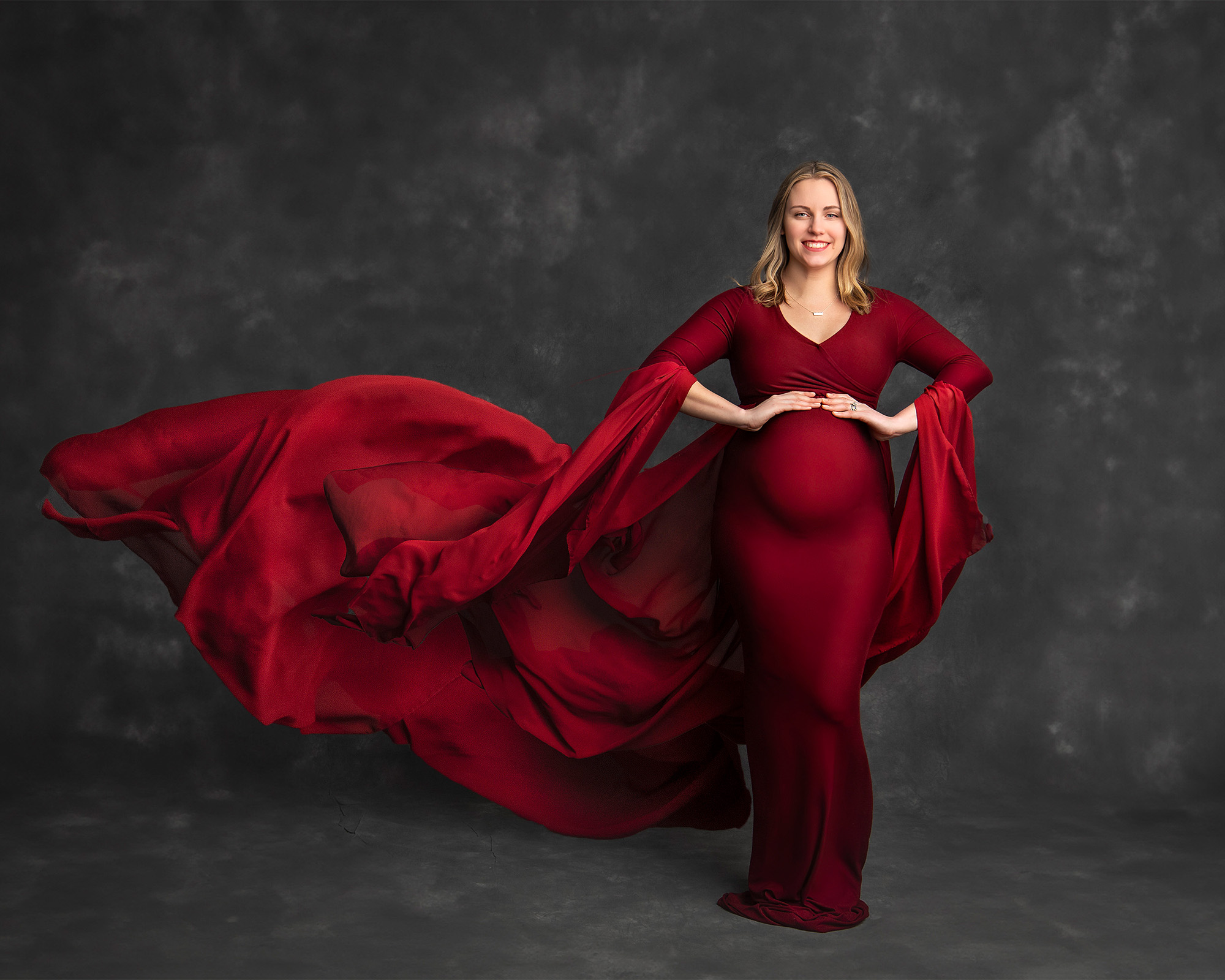 blonde pregnant woman wearing a cranberry flowing gown