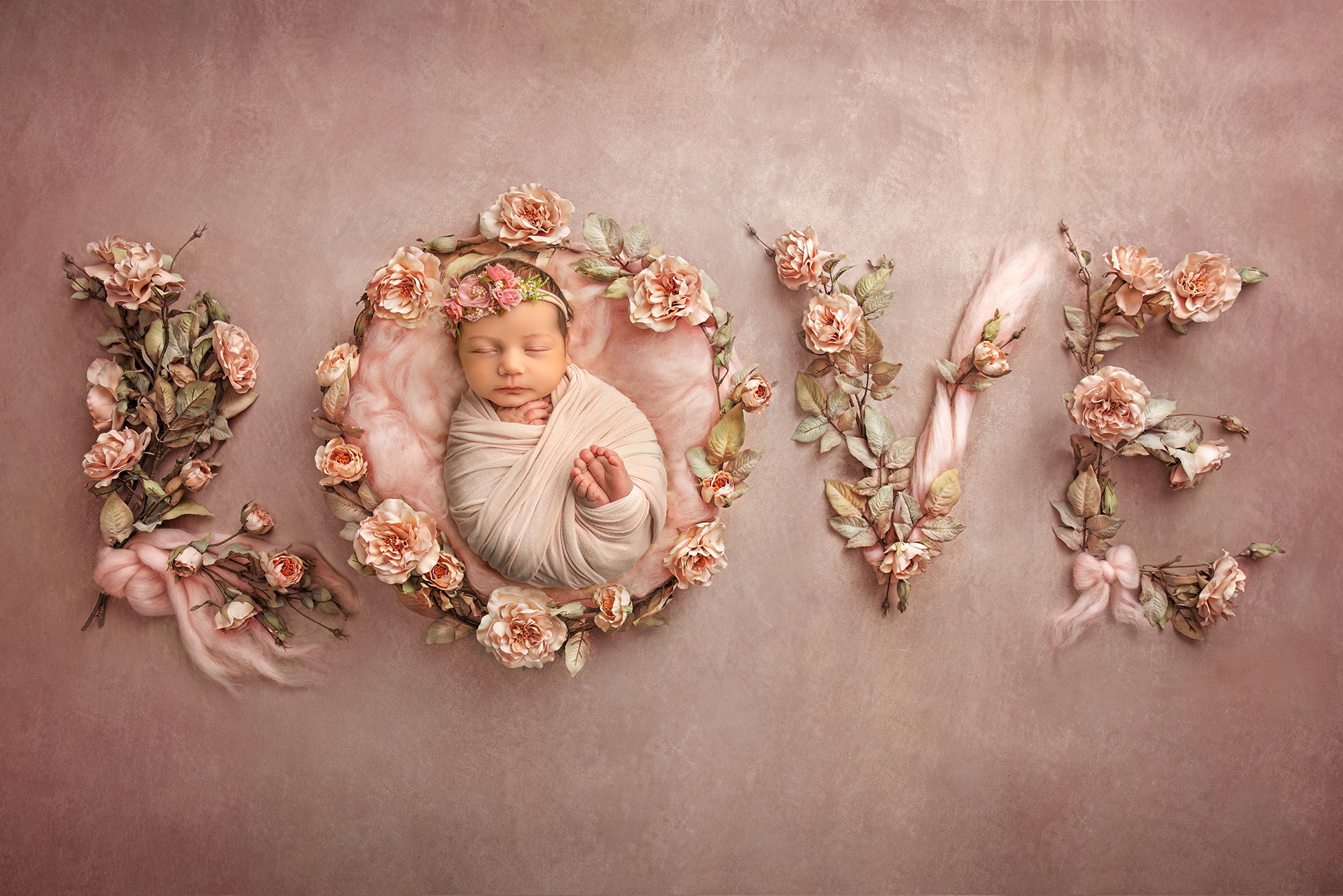 Baby girl laying in a floral version of the word Love, asleep in the O