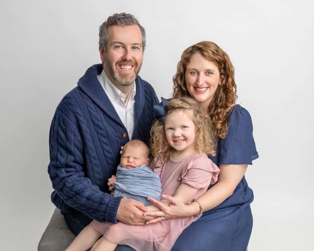 Glastonbury CT newborn photography studio Family holding newborn Tommy in coordinated blue and pink outfits