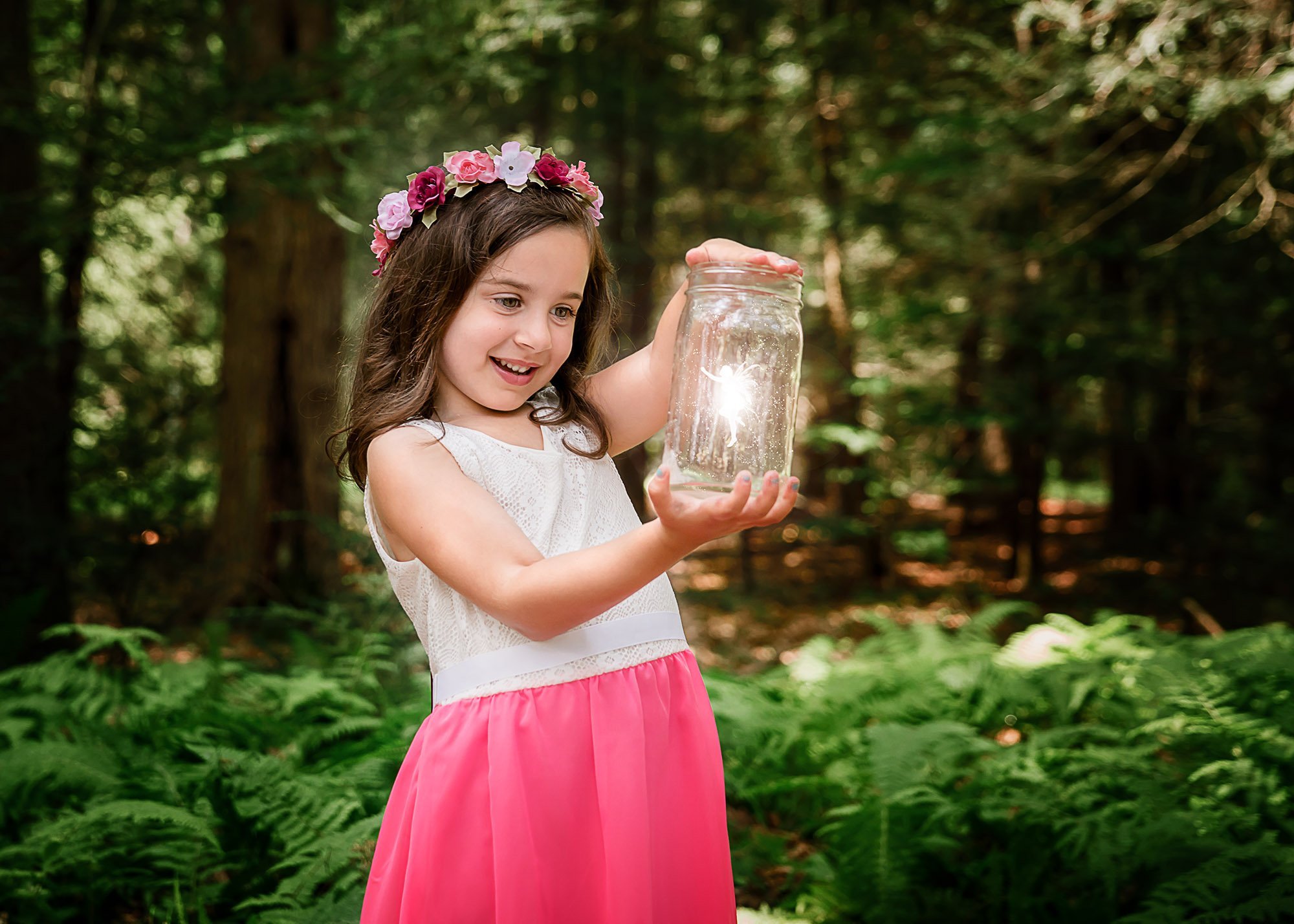 little girl holding a light fairy inside a glass jar