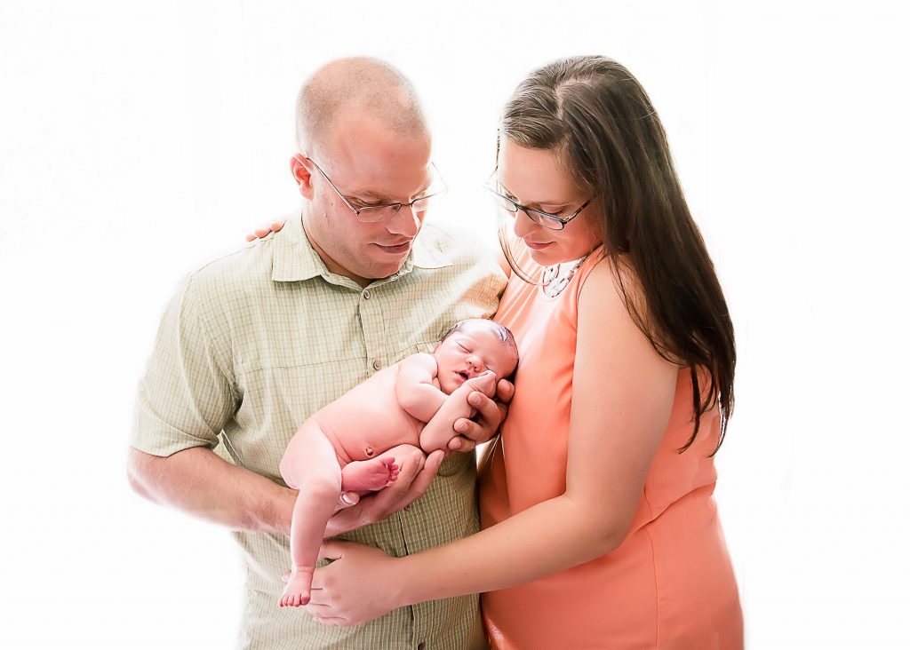 New parents adoring their newborn baby in their arms