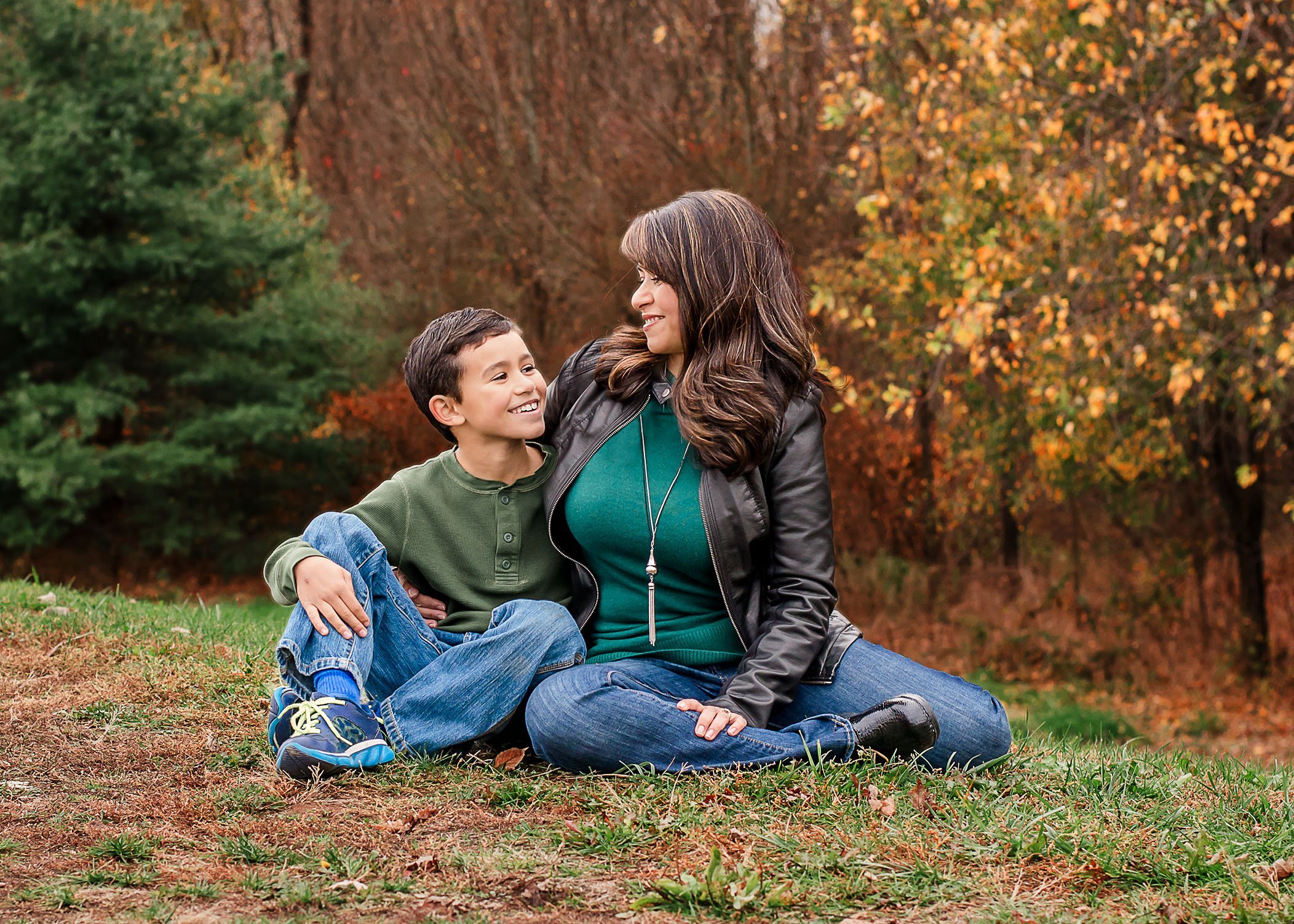 Mom and son sitting outside in fall talking and laughing