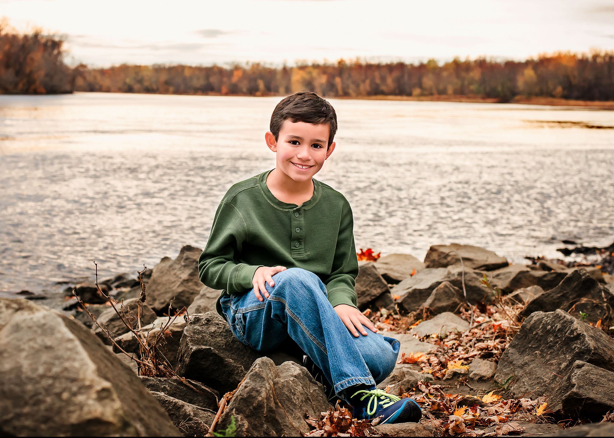 little boy sitting on rocks by the Connecticut river