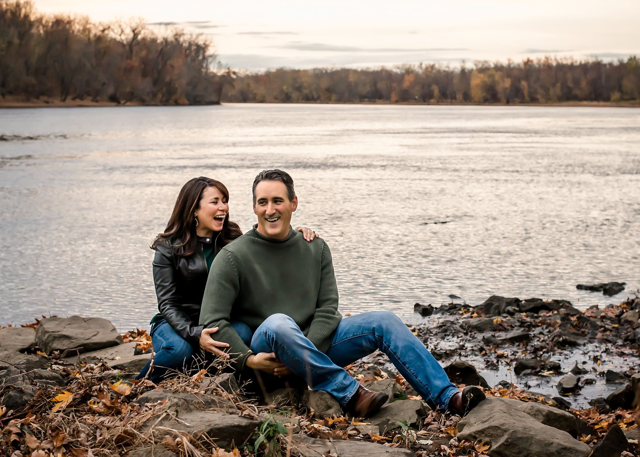 Couple sitting by the Connecticut river laughing together