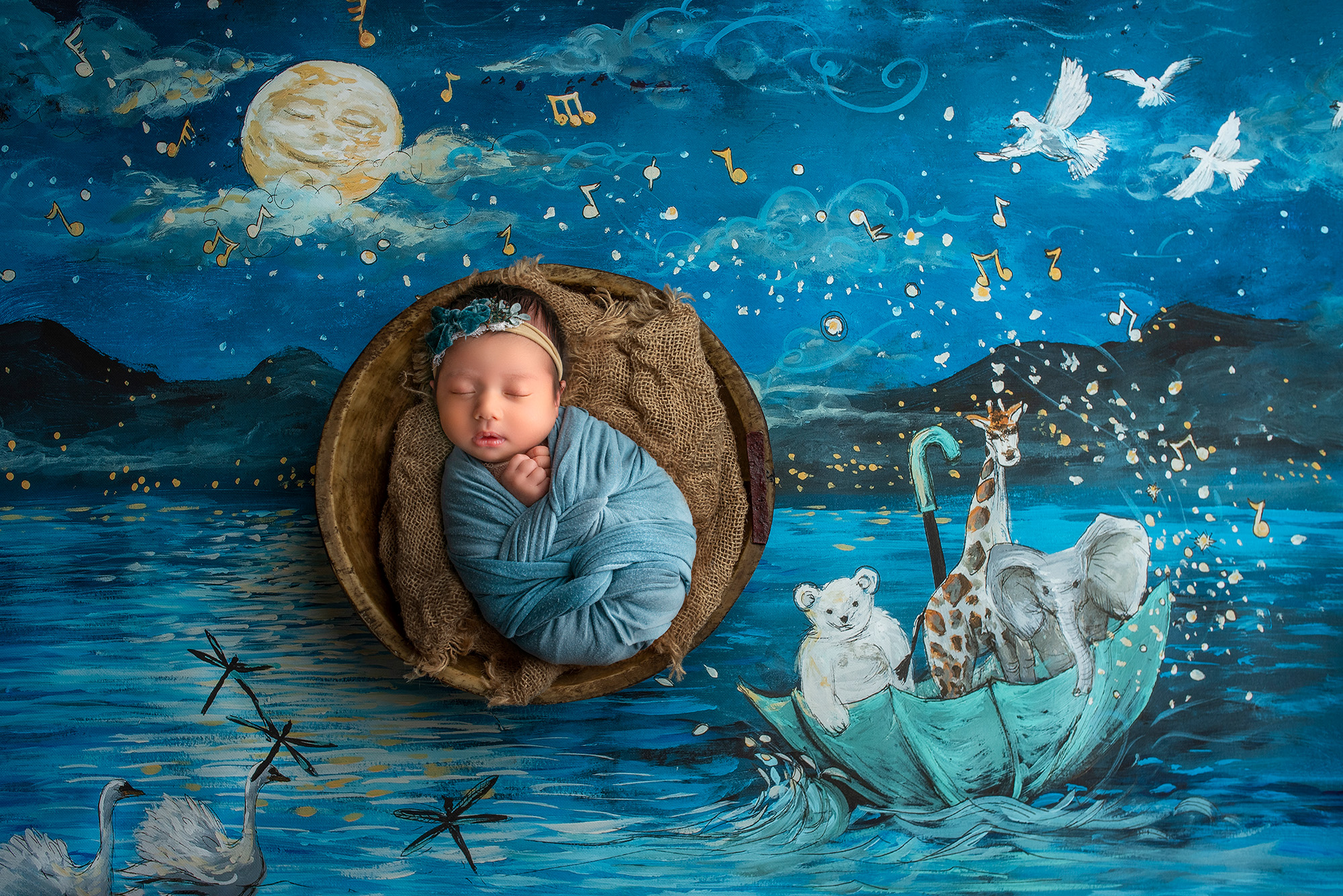 posed newborn photography session Sophie wrapped in a swaddle amidst whimsical characters.