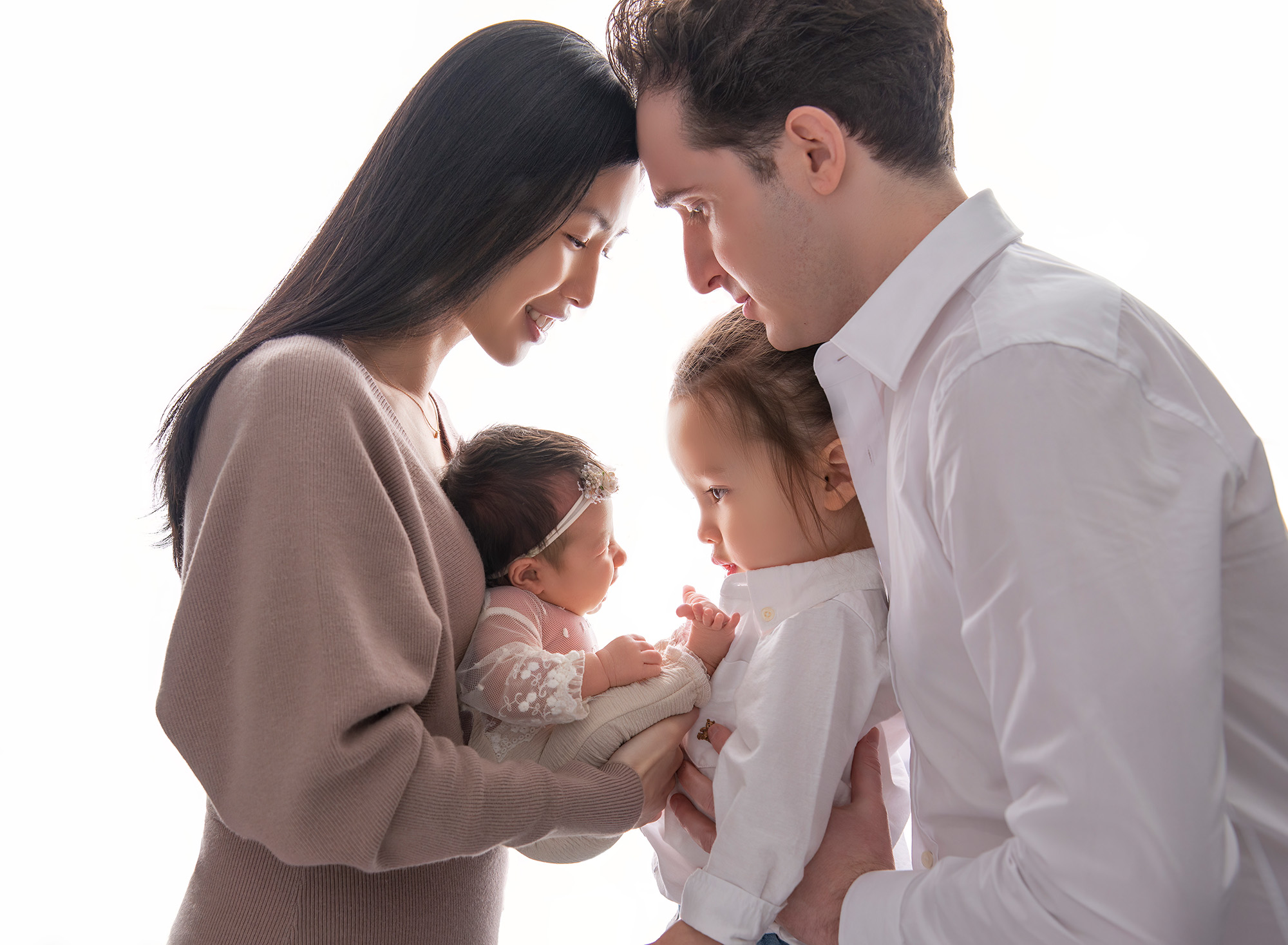 posed newborn photography session Family portrait with Mom, Dad, Joshua, and Sophie radiating love and joy. 