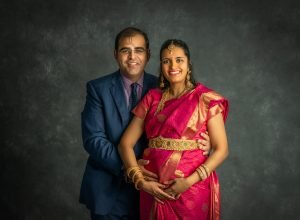 pregnant woman posing with husband in traditional costume