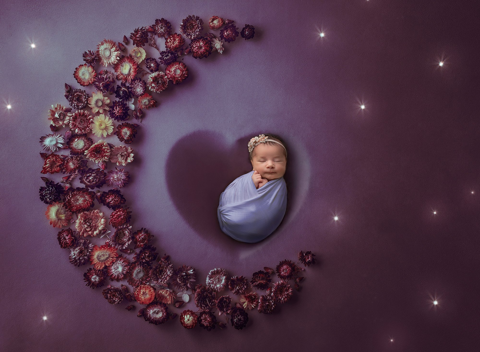 baby girl swaddled in purple sitting in a heart on a starry background with a moon consisting of purple and pink flowers
