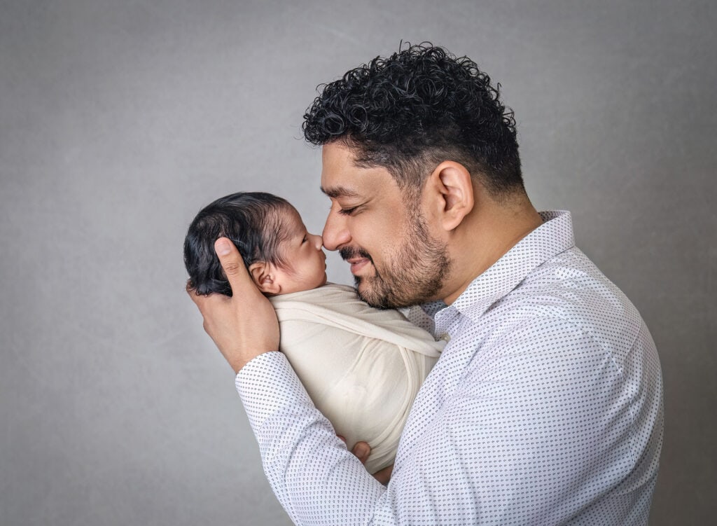 newborn and family photography side profile of father holding baby cheek-to-cheek
