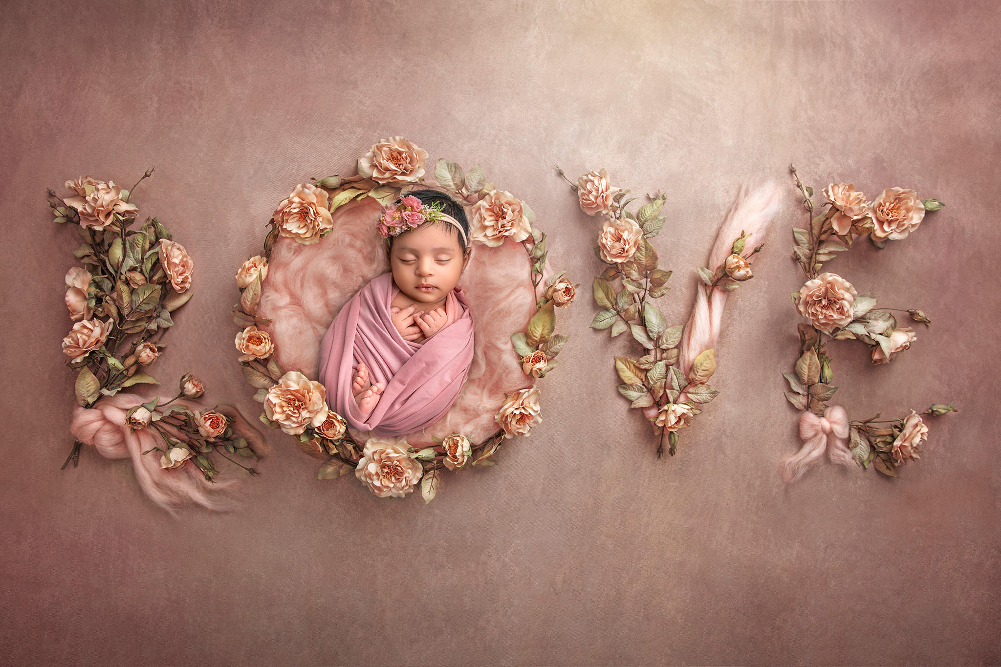 Word “LOVE” spelled in roses with baby Dhanya sleeping in the letter “O"