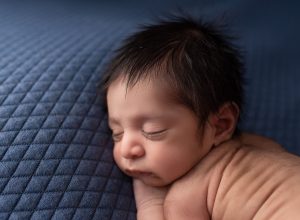 newborn baby boy asleep with long eyelashes and his back wrinkles showing best time to take newborn photos