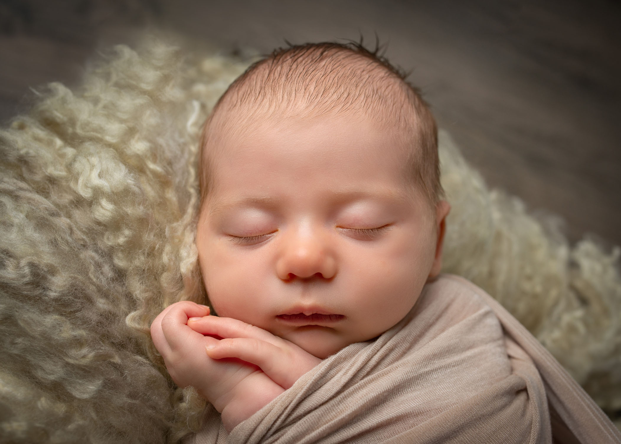 close up of newborn baby sleeping with hands under cheek