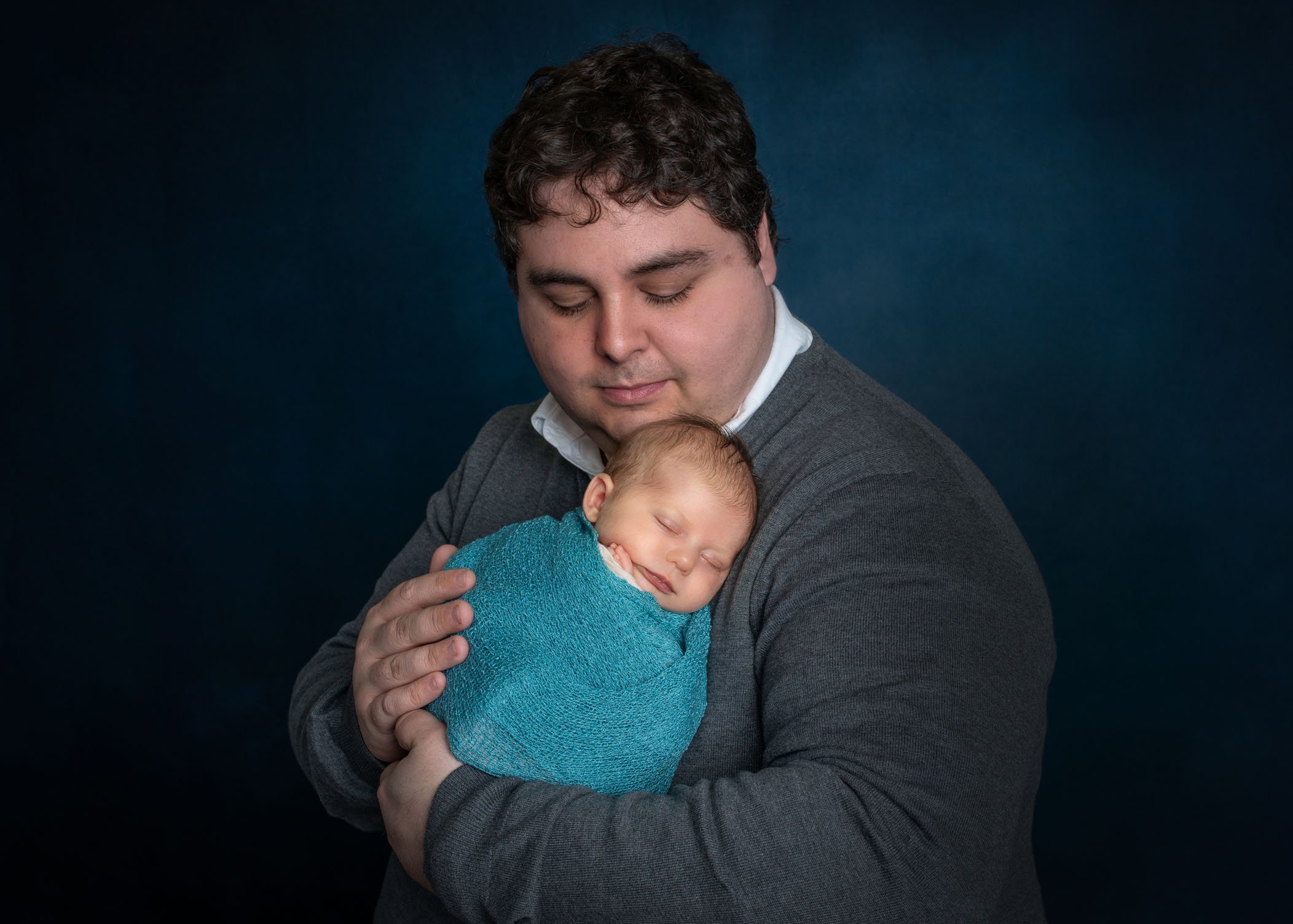 Dad holding newborn on his shoulder