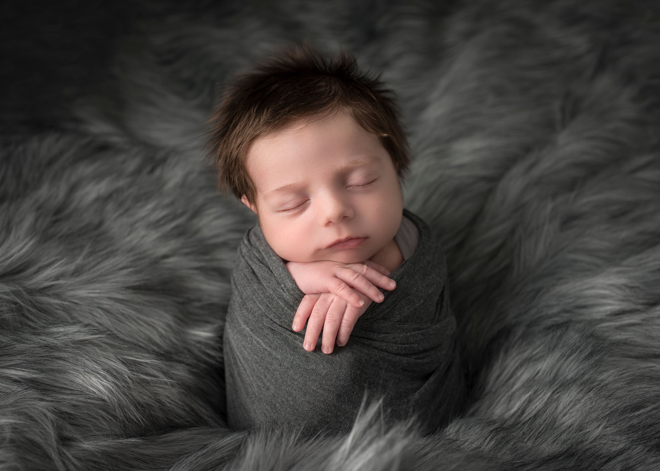 newborn baby boy potato sack pose sleeping in grey fur