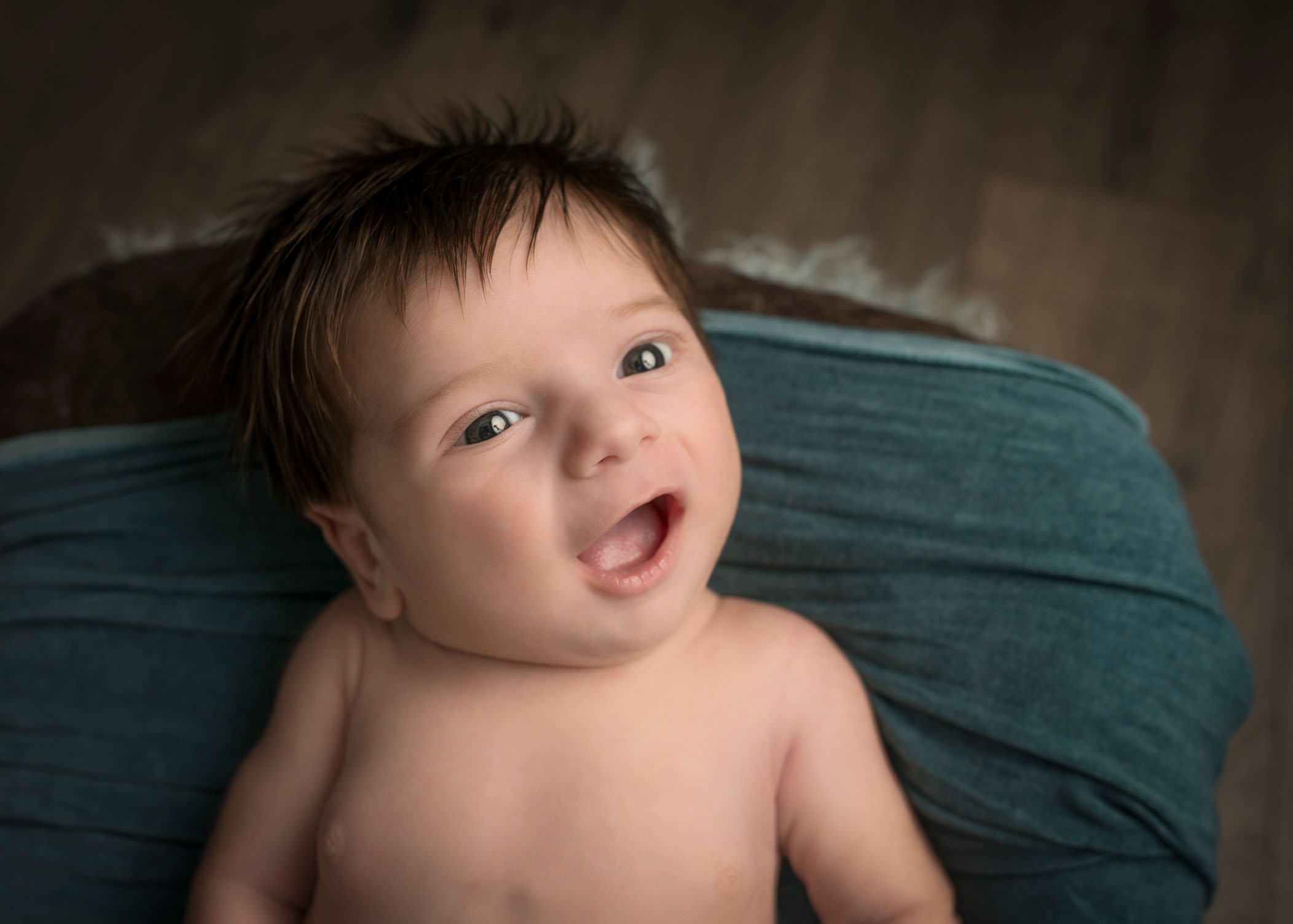 newborn baby boy laughing at camera