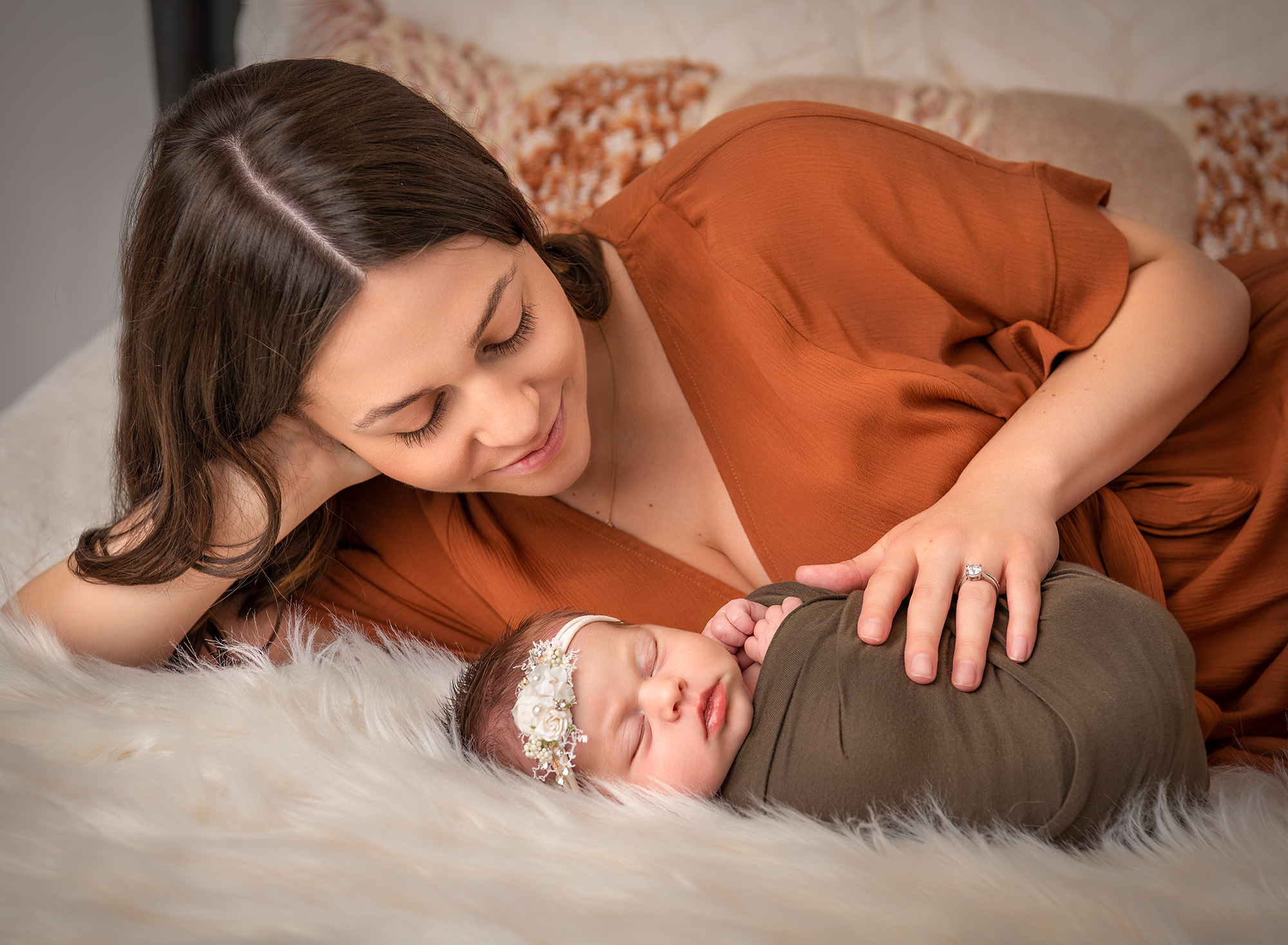 best newborn photography mom watching her new baby sleep with her hand on baby's tummy