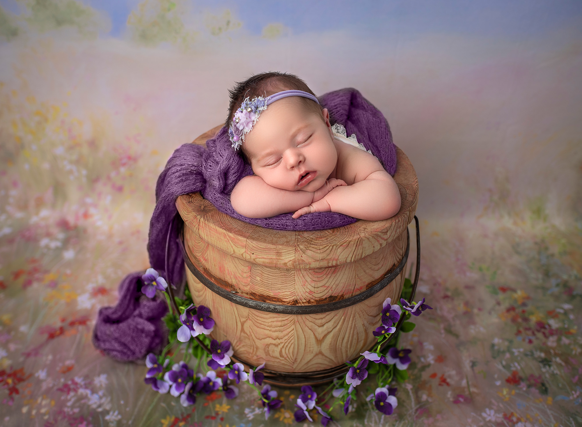 best newborn photography baby sleeping in a wooden honey bucket