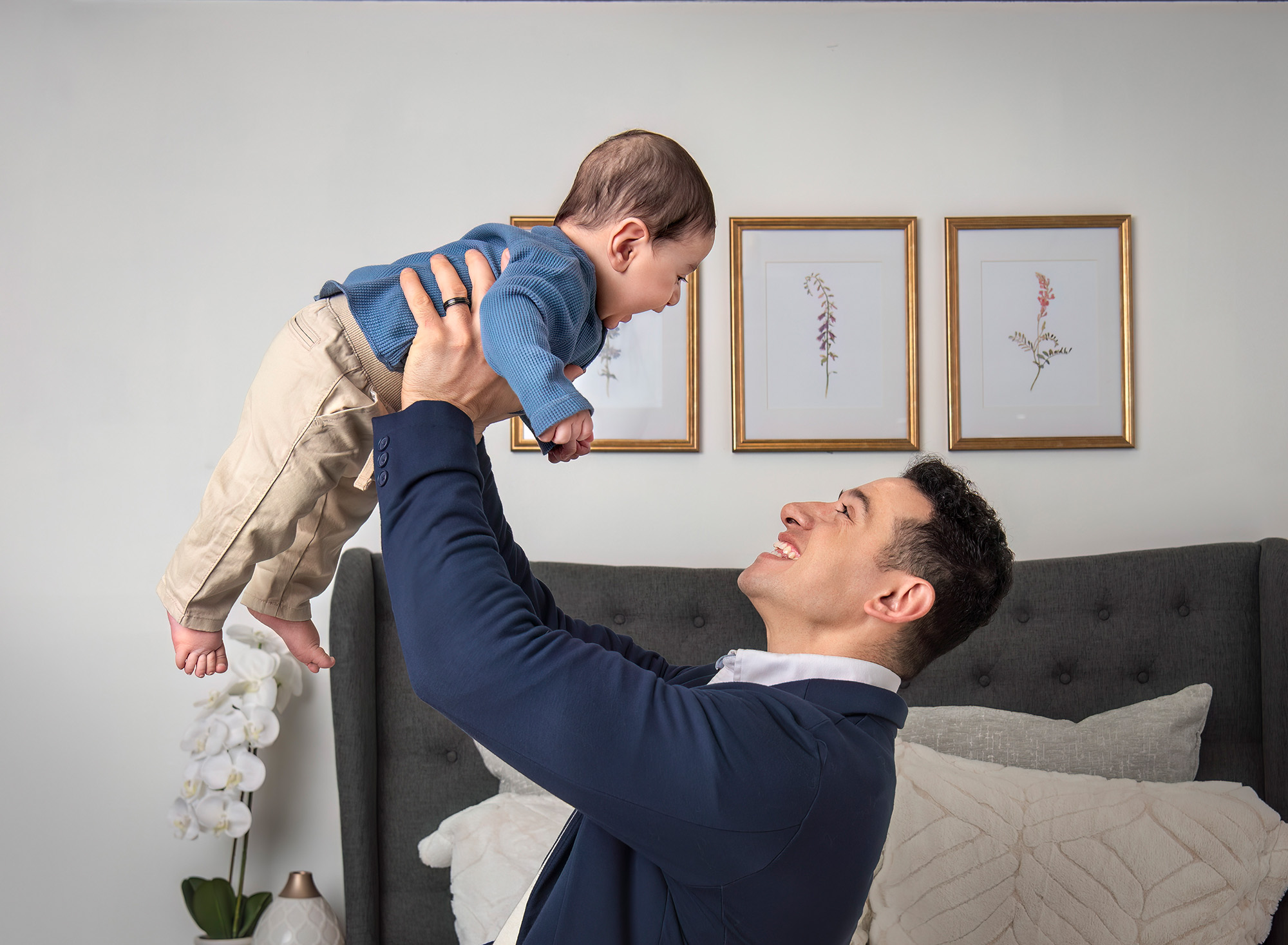 Candid In Studio Family Photos Father lifting baby up in the air, both smiling