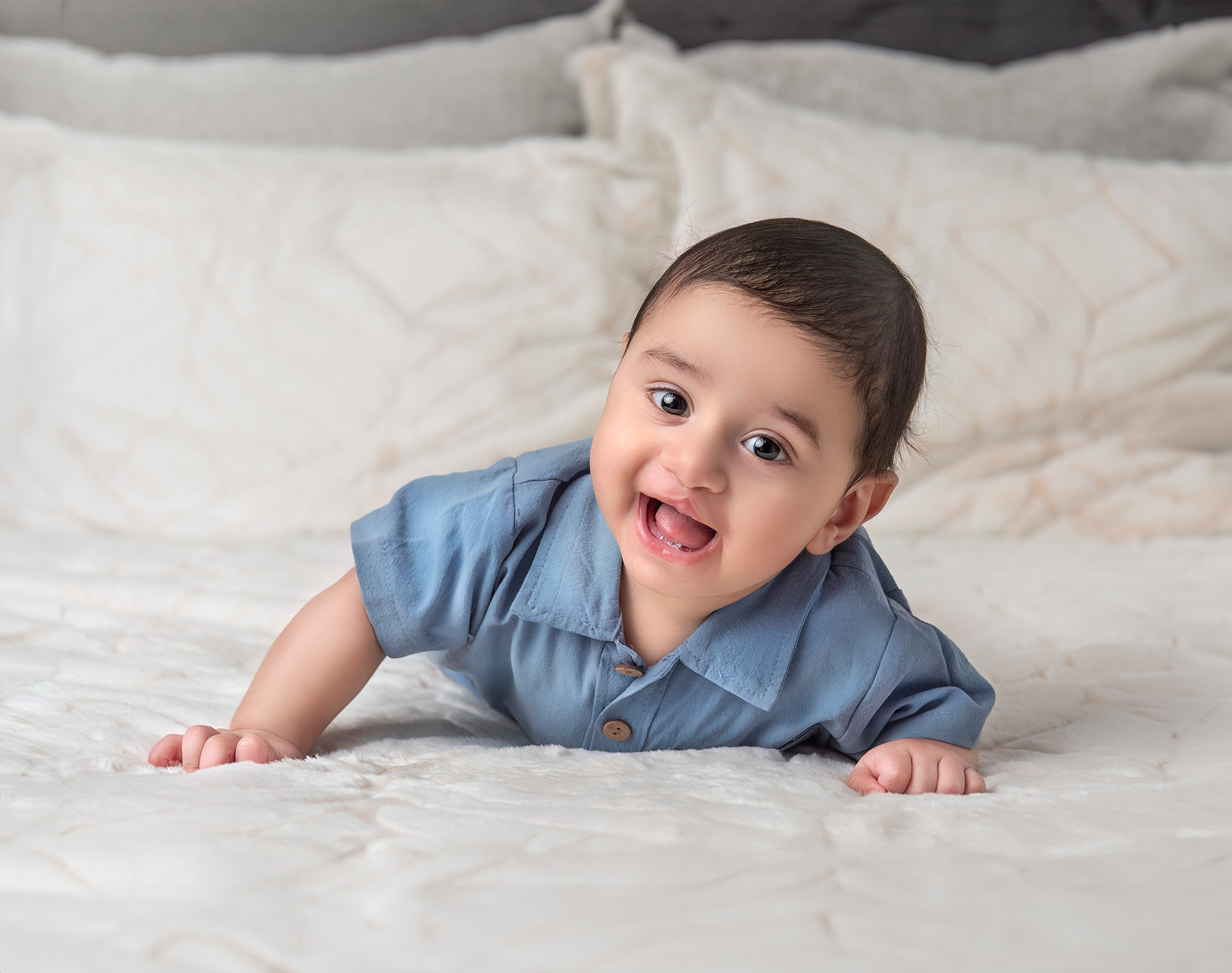 Three month old smiling on the bed